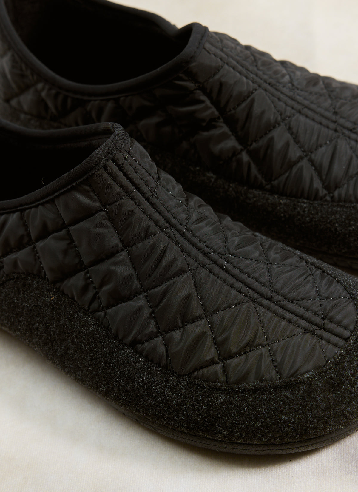 A close-up of the Gurus Valencia Classic Homeshoe in black, highlighting the quilted nylon upper and felt foxing tape.