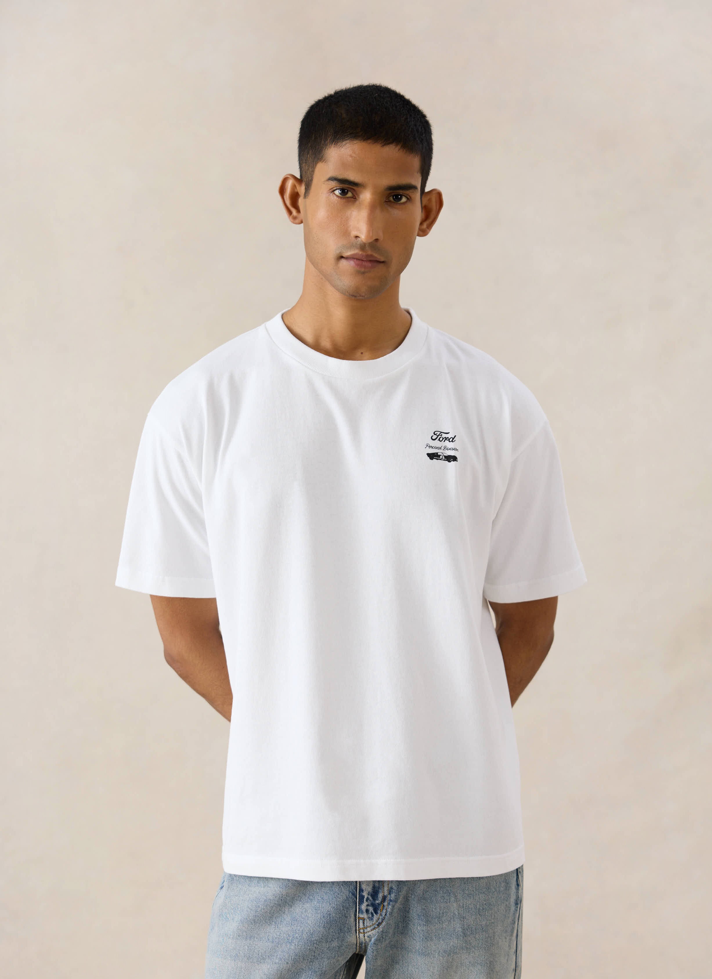 White Ford x Percival Le Mans oversized organic cotton t-shirt, styled on a model with light blue Percival jeans.