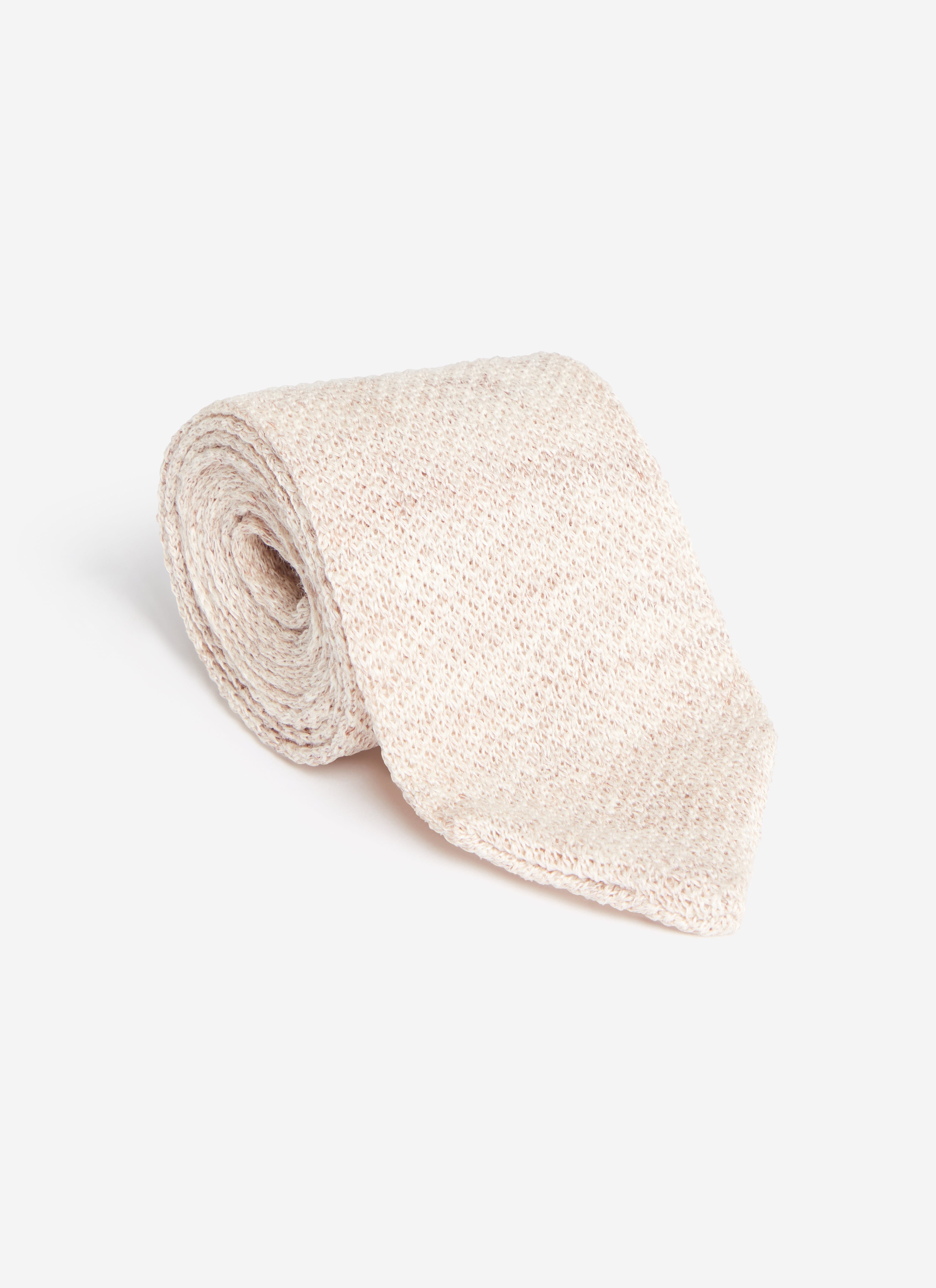 A flat lay of the Percival Linen Tie in Oat Marl, rolled up to display its textured linen weave.