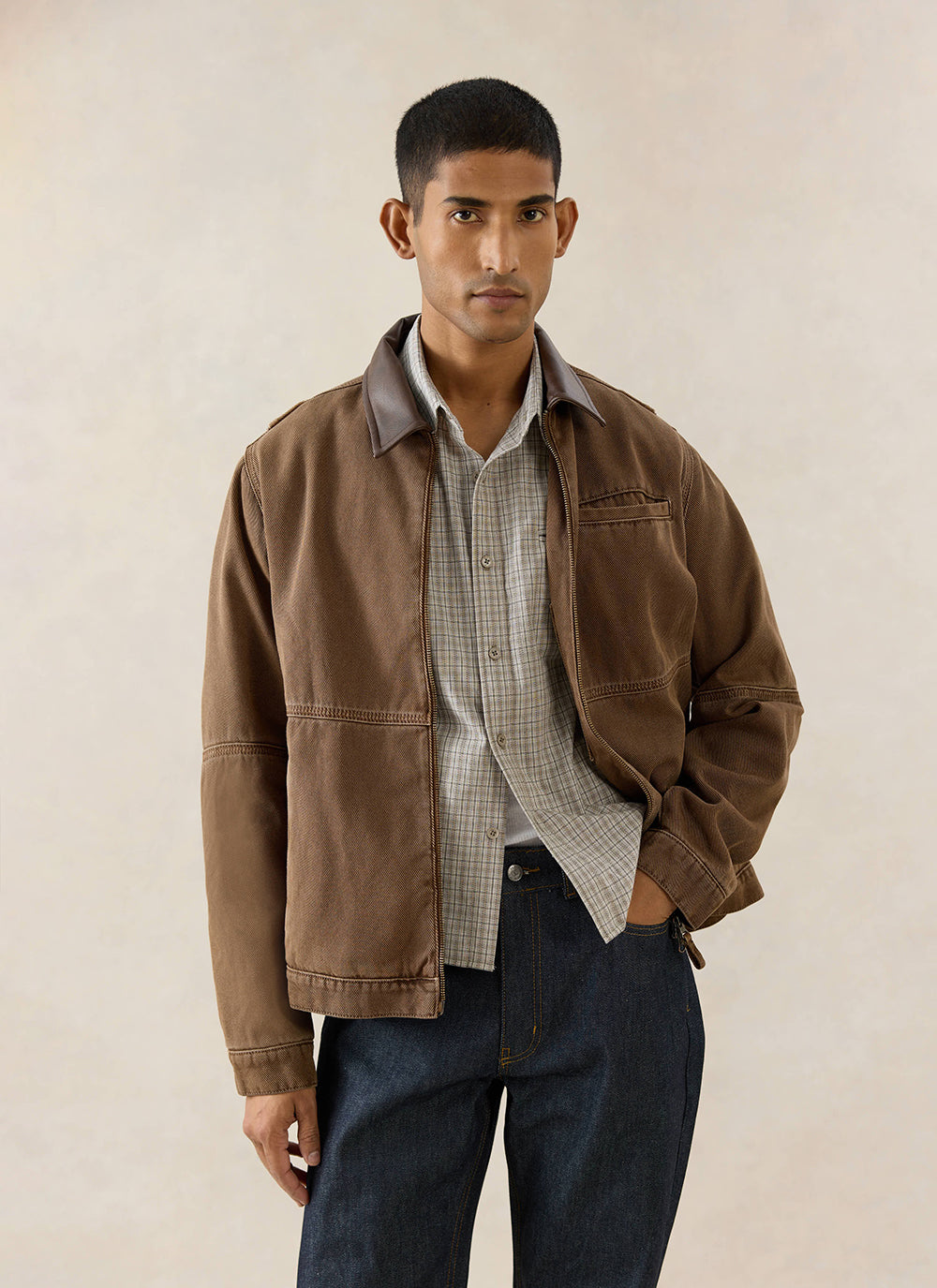A model wears the Percival Lucas Vintage Wash Contrast Collar Jacket in mocha, styled with a checked shirt and dark jeans.