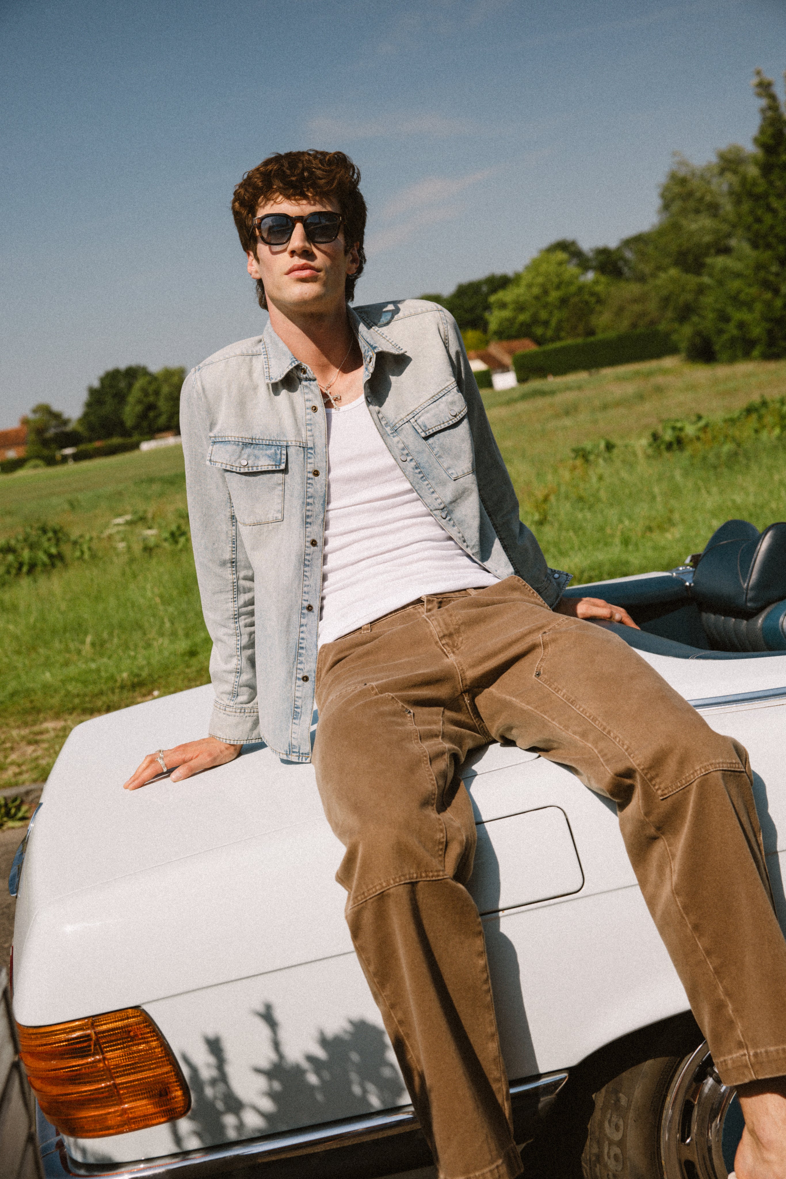 Percival stone wash denim Western shirt and mocha Lucas Carpenter trousers, styled on a model by a white vintage car.