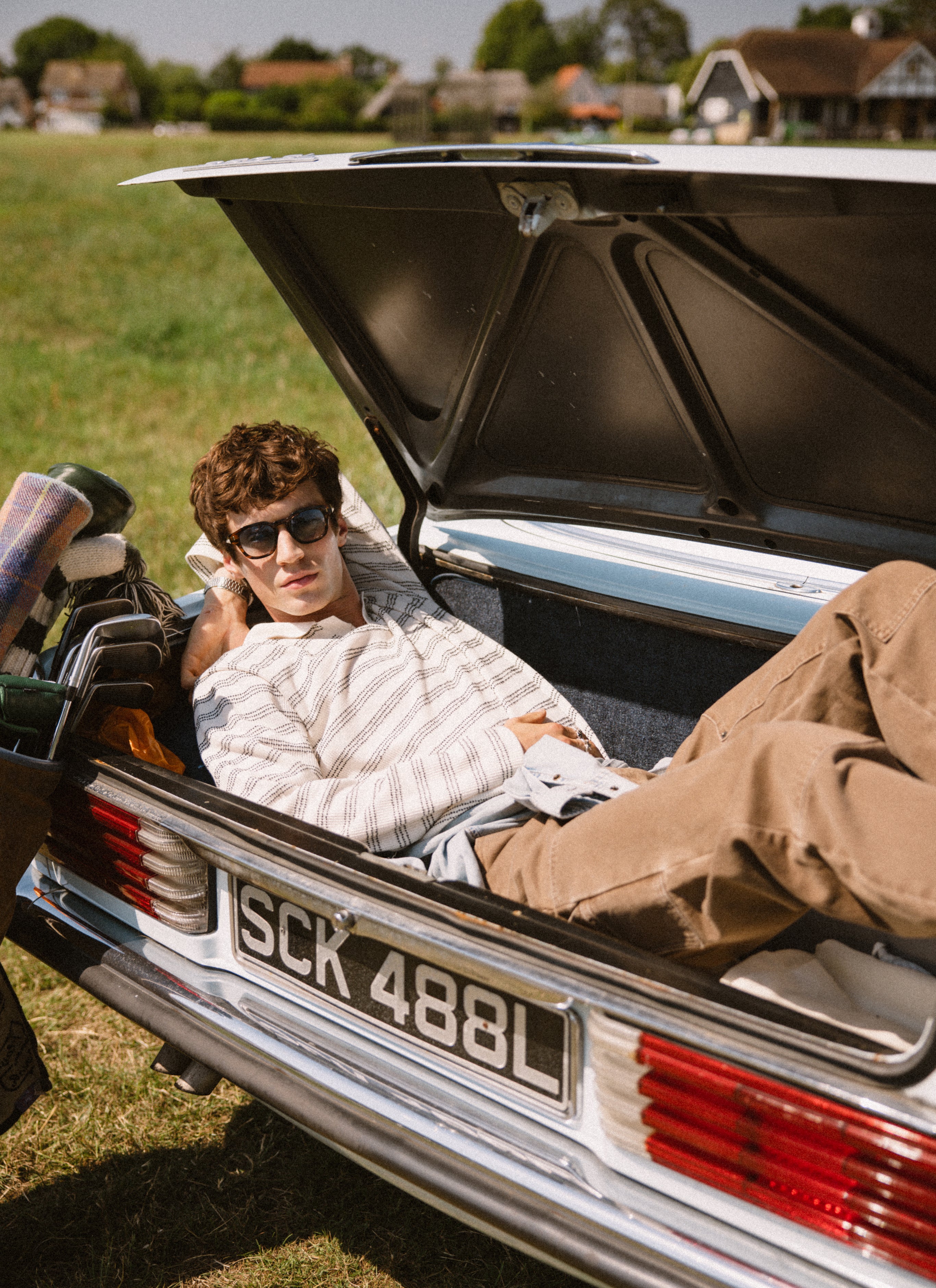 Percival Laurent cream stripe long sleeve polo and brown Lucas trousers, styled in the boot of a vintage car.