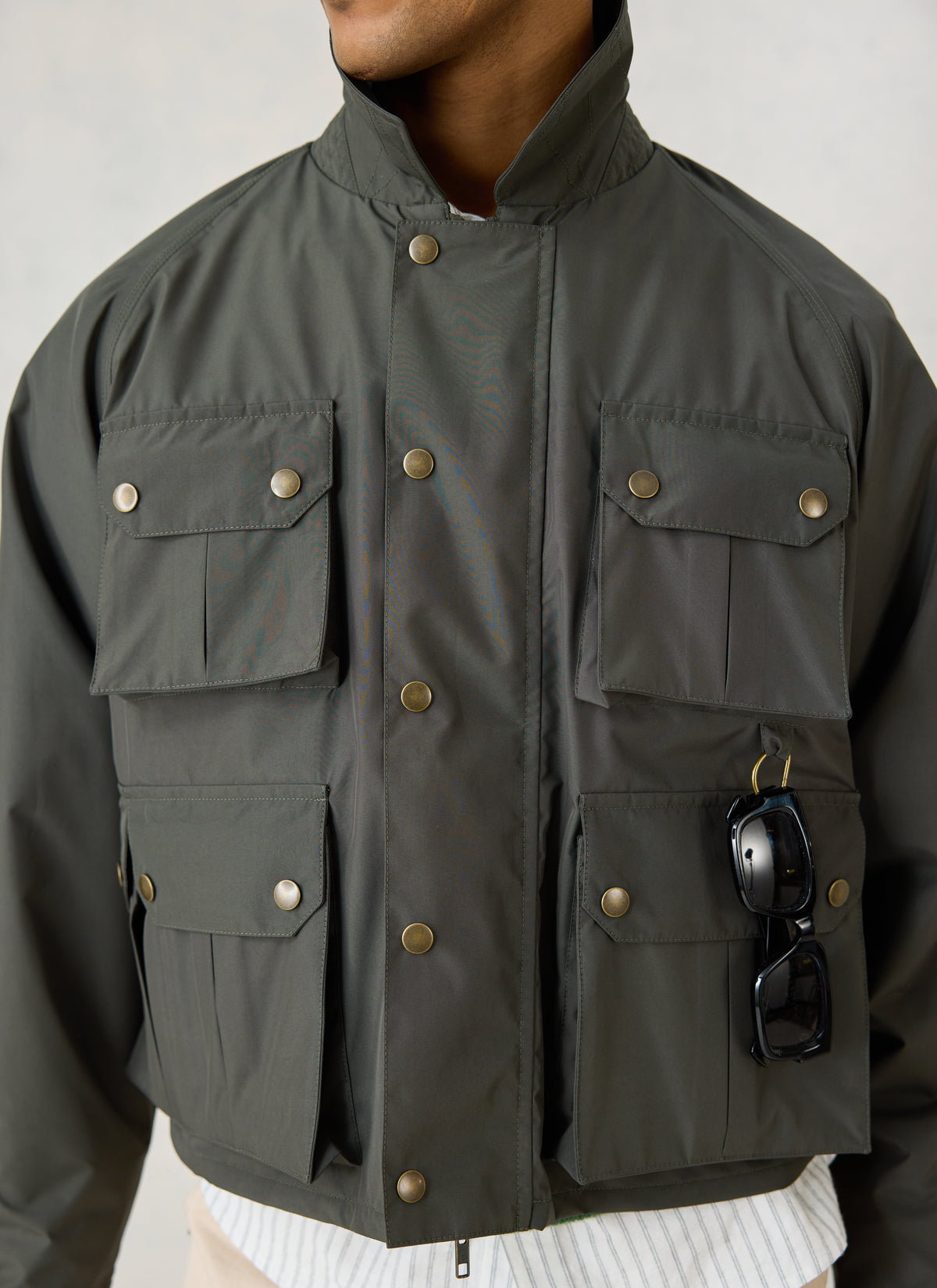Close-up of the Percival forest green Hunter Jacket, showing the four front pockets, popper fastenings, and turned-up collar.