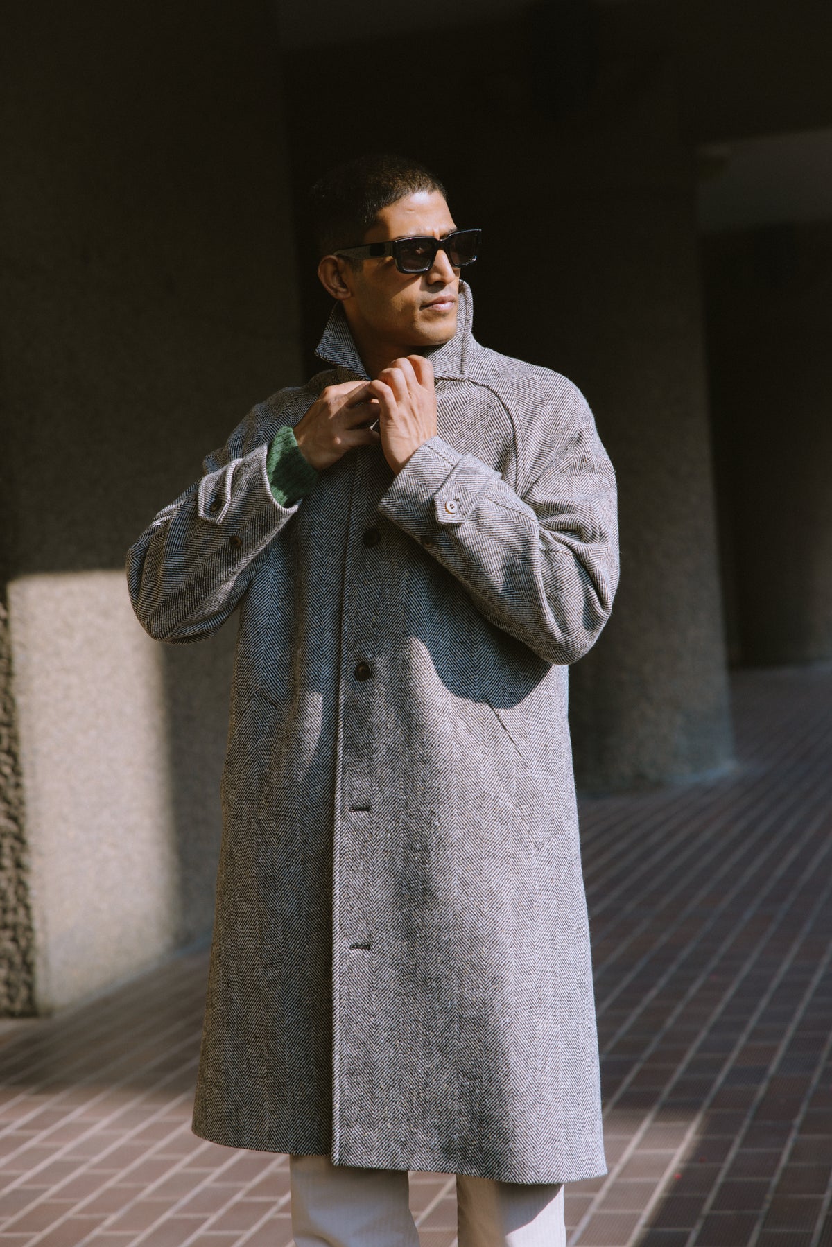 Model wearing grey herringbone wool Percival Car Coat outdoors.