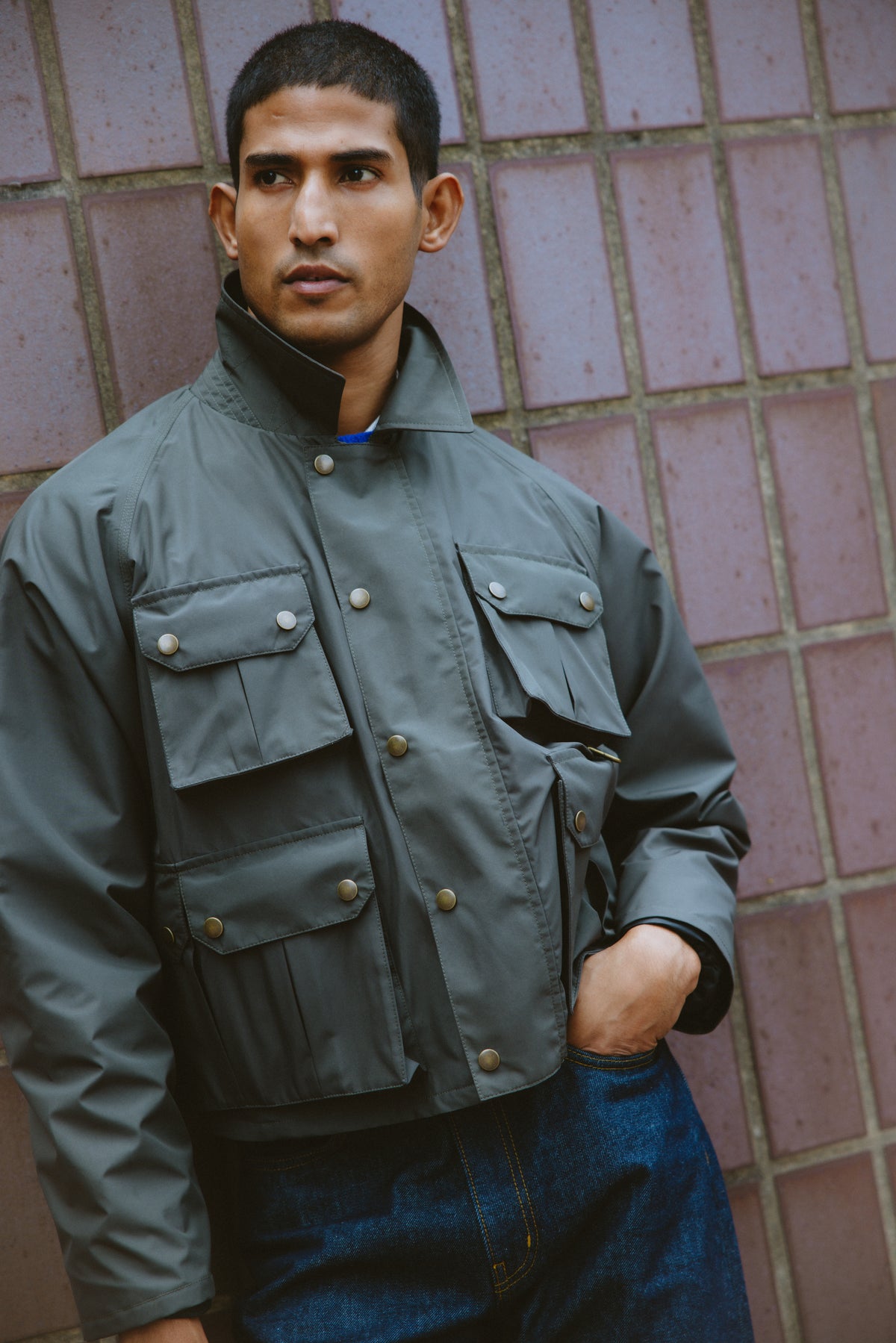 A model wearing the Percival forest green Hunter Field Jacket with four front pockets and a popped collar.