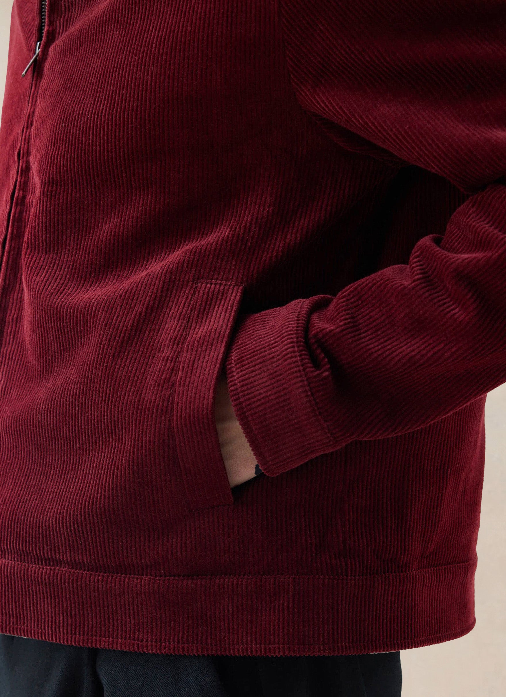 A close-up of the burgundy Percival cord jacket, highlighting the heavy wale corduroy texture and pocket detail.