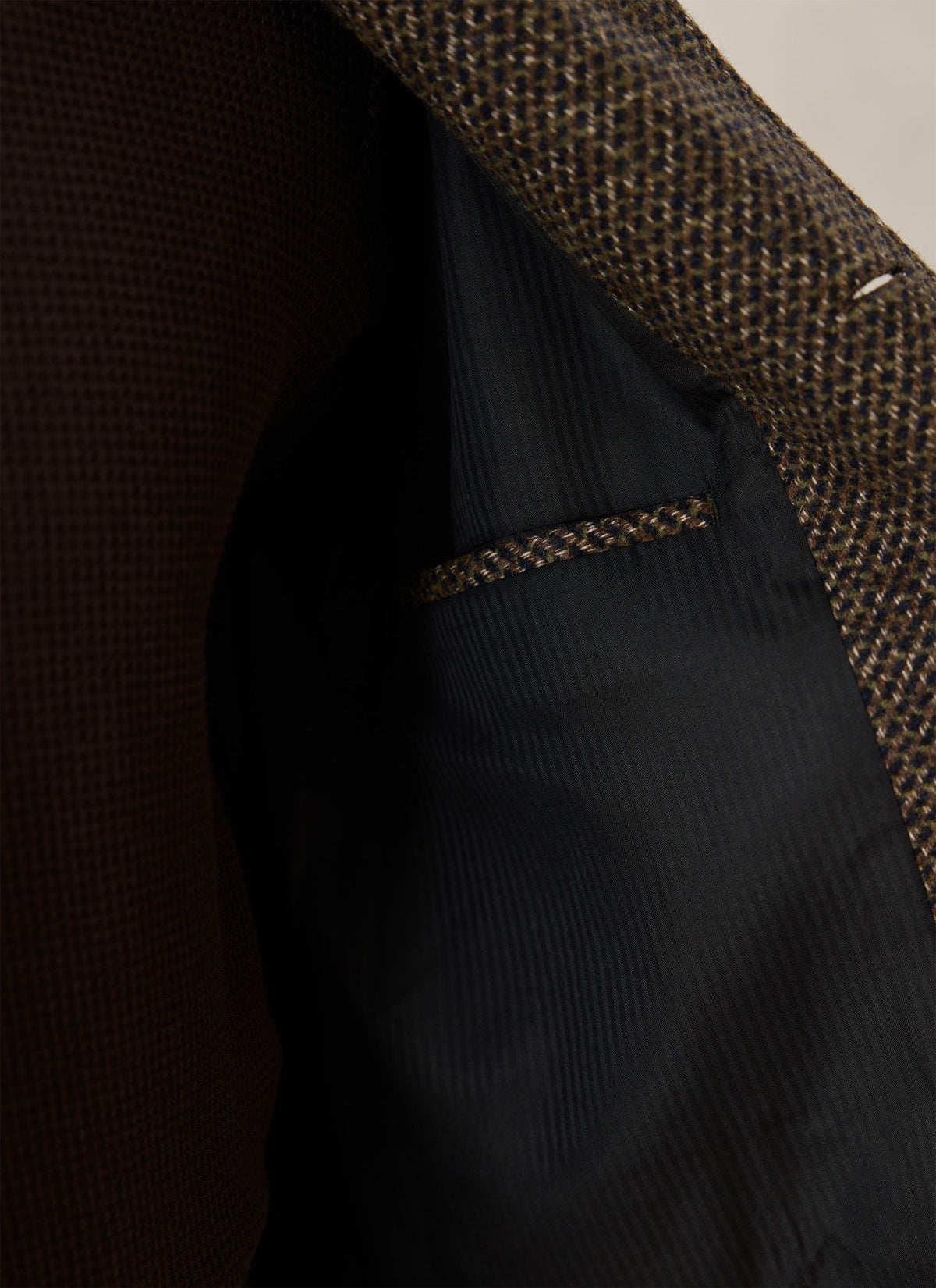 A close-up of the Percival brown fleck wool-blend Mason car coat showing the dark lining and internal pocket.