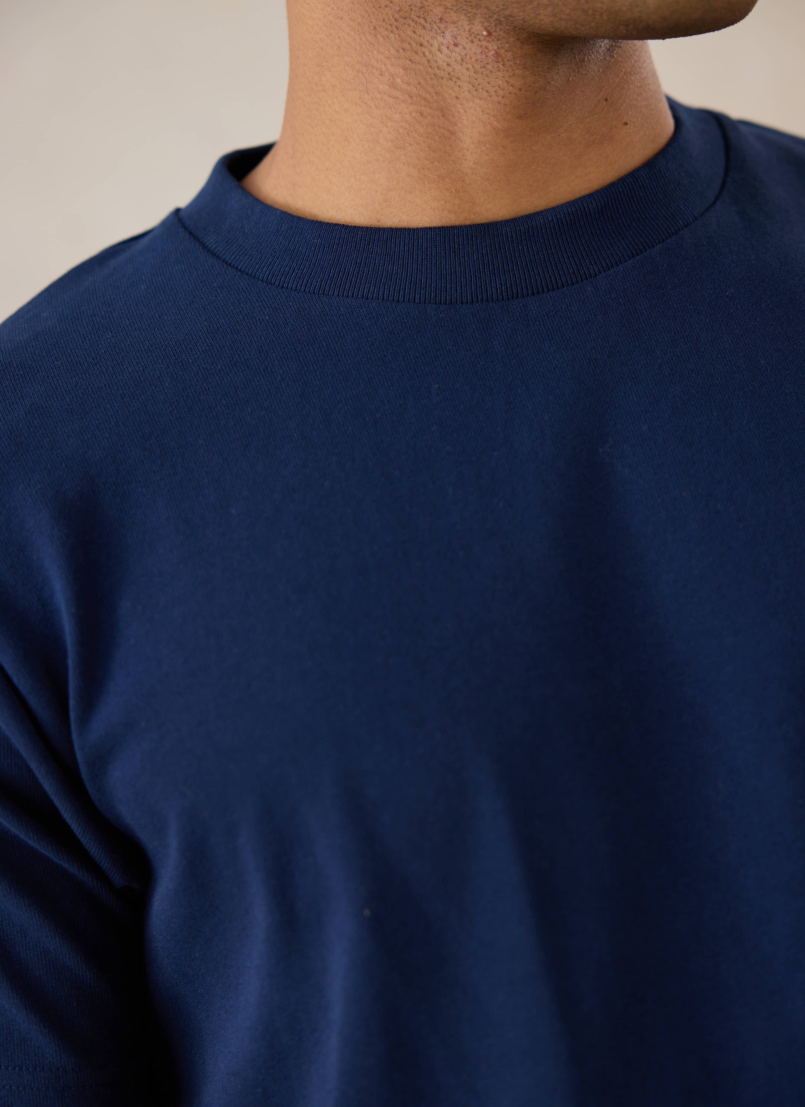 Model wearing Percival's Plain Regular T Shirt in Navy with Percival Cream Jeans.