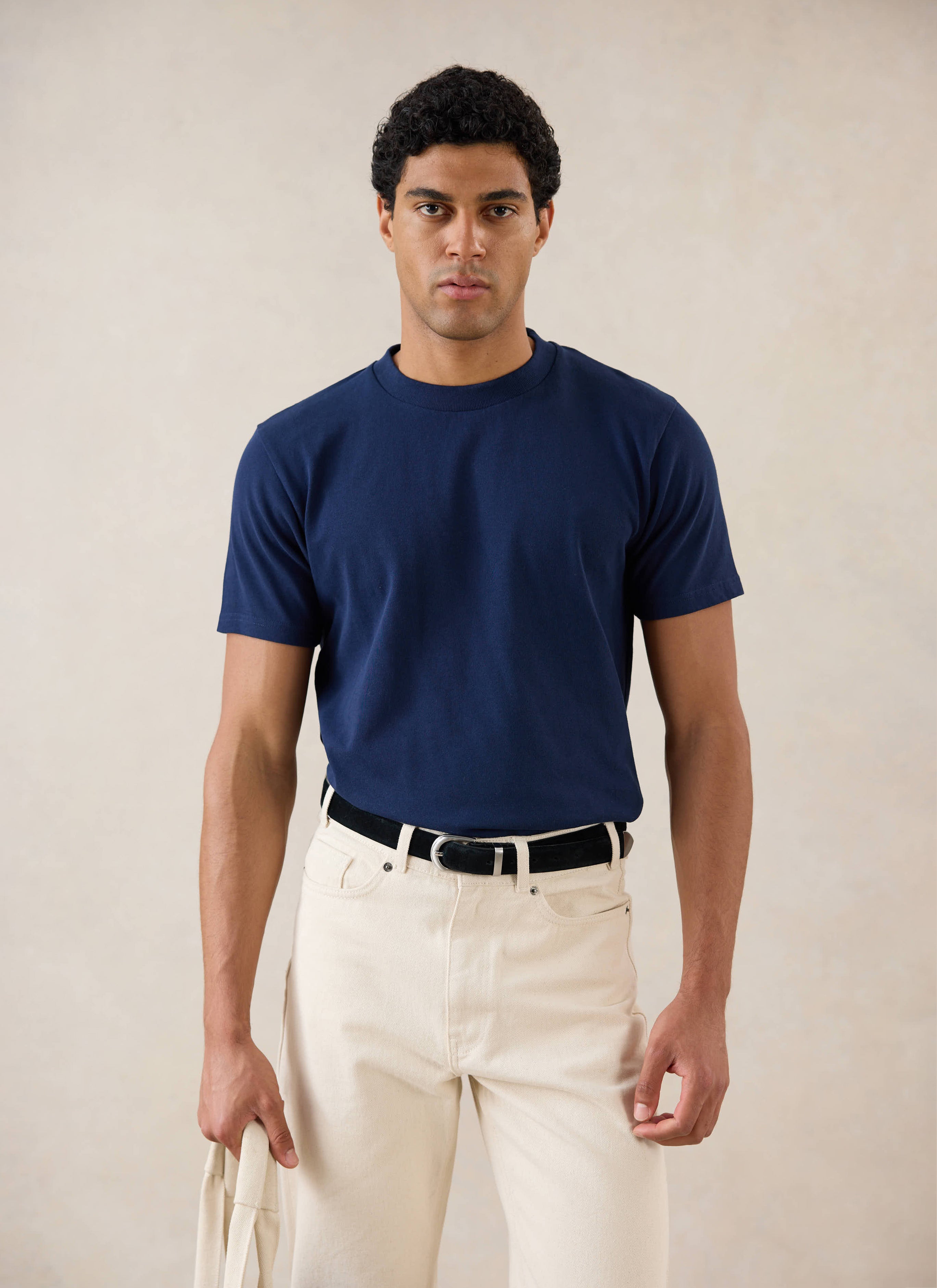 Model wearing Percival's Plain Regular T Shirt in Navy with Percival Cream Jeans.