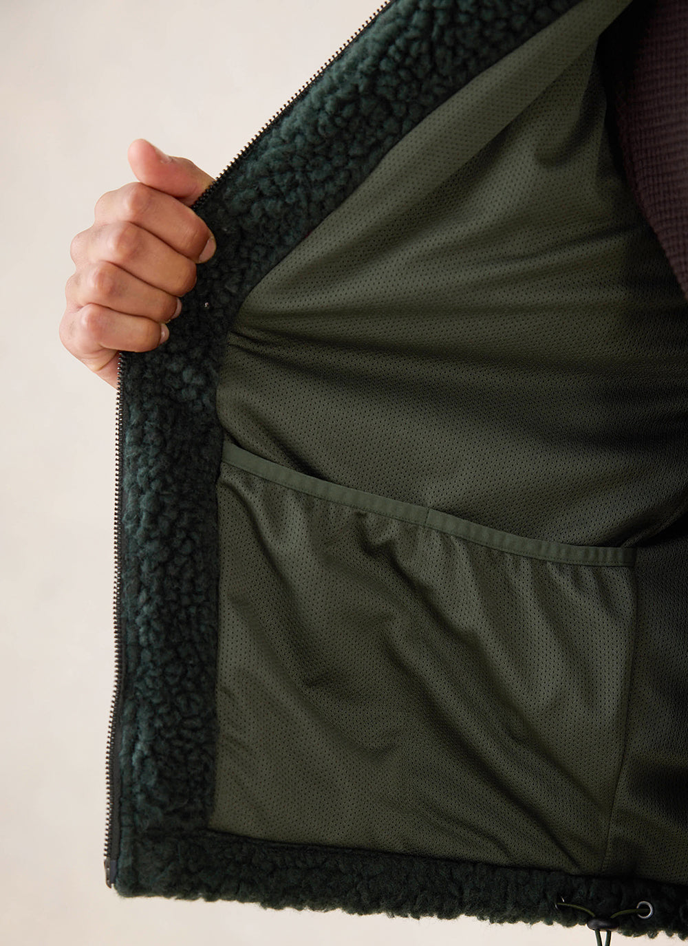 Close-up of the interior lining and pocket of the forest green wool fleece jacket from Percival.