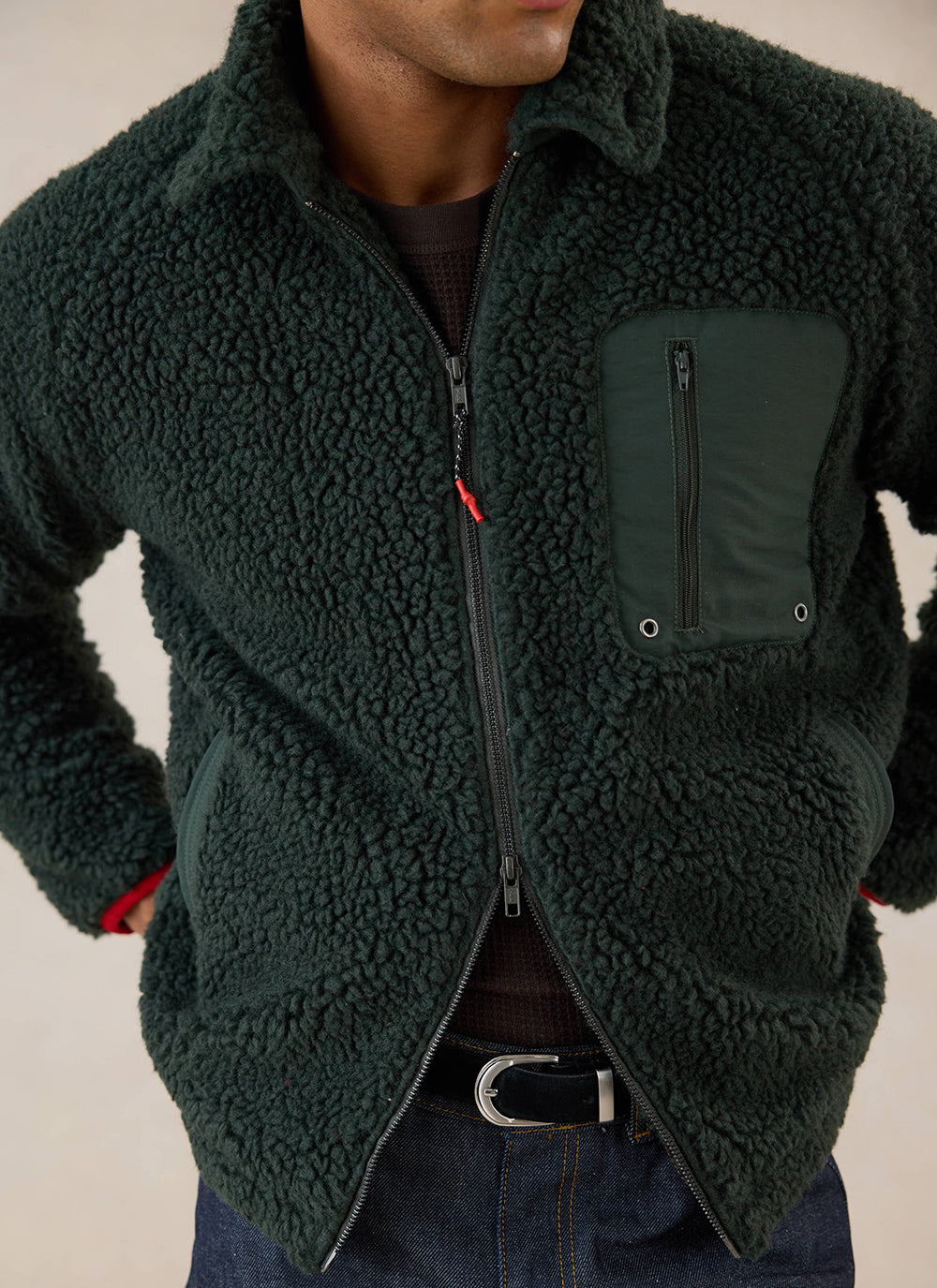 Close-up of a Percival forest green wool blend fleece jacket featuring a zip front, chest zip pocket, and contrast details.