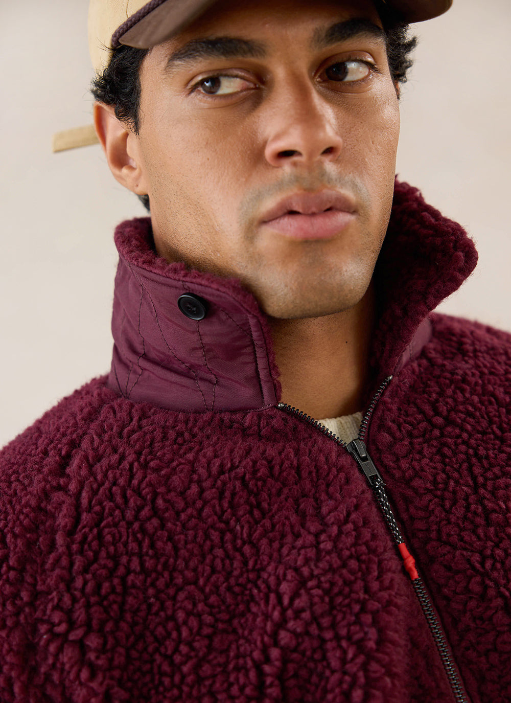 Close-up of a model wearing the Percival burgundy wool blend fleece jacket with a stand collar.