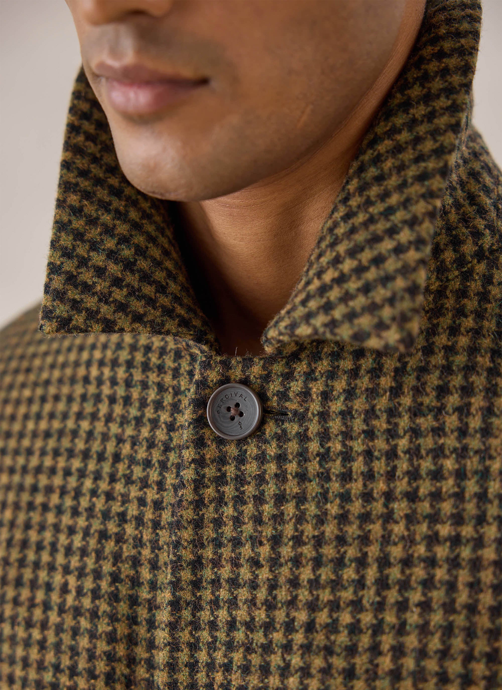 A close-up shot of the collar and button detail on the Watcher Check Minnesota Overcoat from Percival.