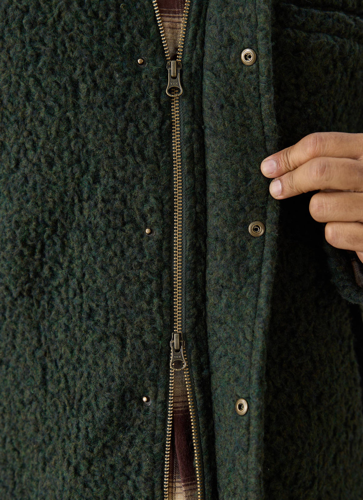 Close-up of the Percival forest green wool-blend fleece jacket showing the two-way zip and press-stud placket.