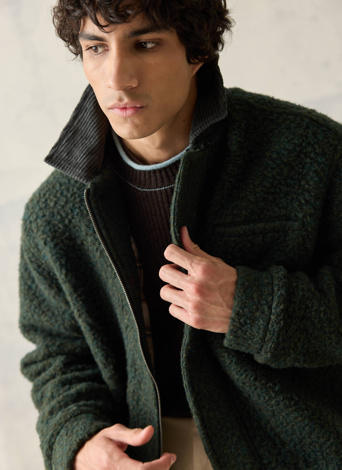 A model wearing the Percival forest green Murrey fleece jacket with a cord collar over a brown Hurst ribbed knit jumper.