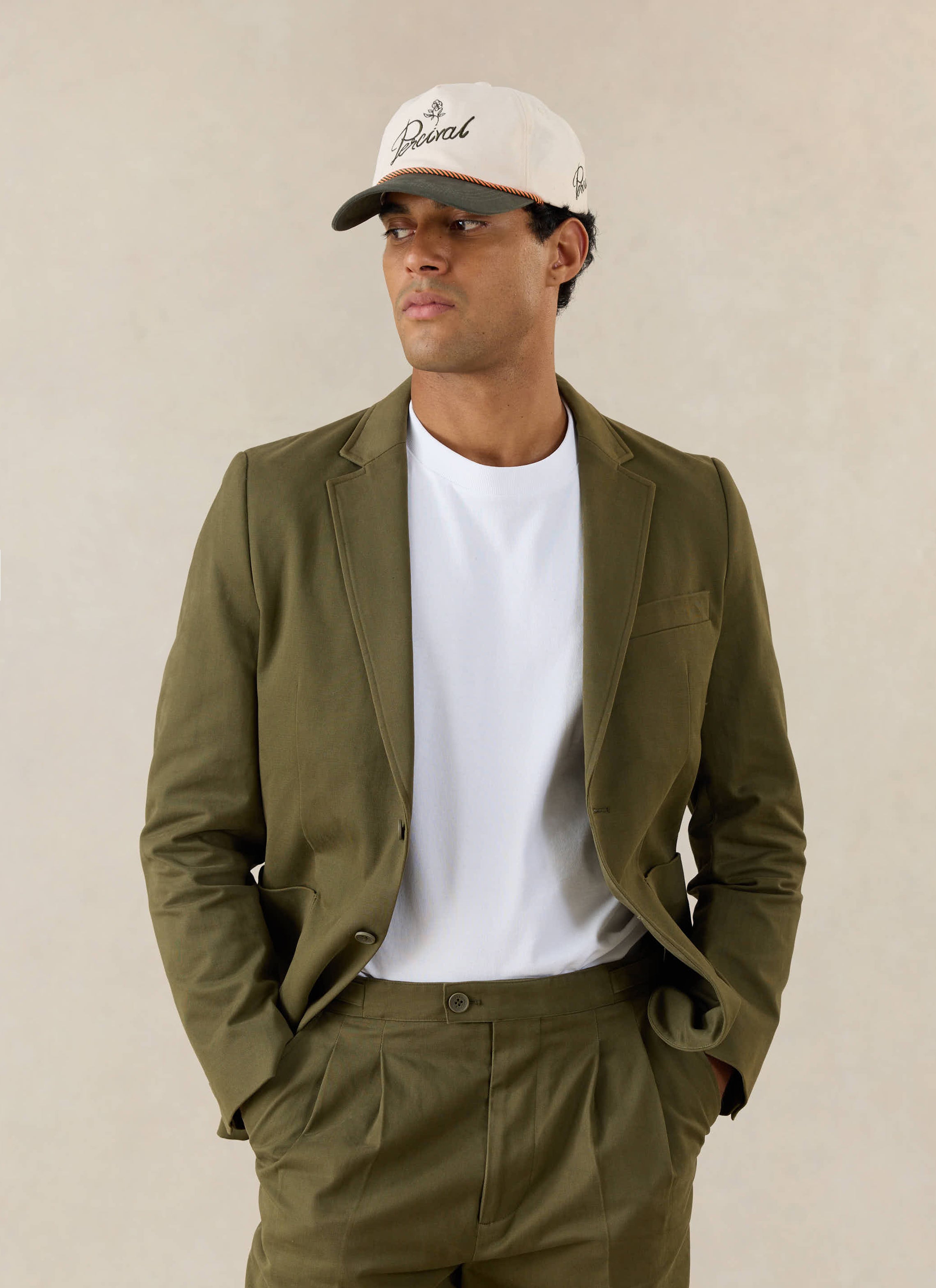 A model wears the Percival Blake Tailored Blazer in Forest Green Brushed Moleskin with matching trousers and a white tee.