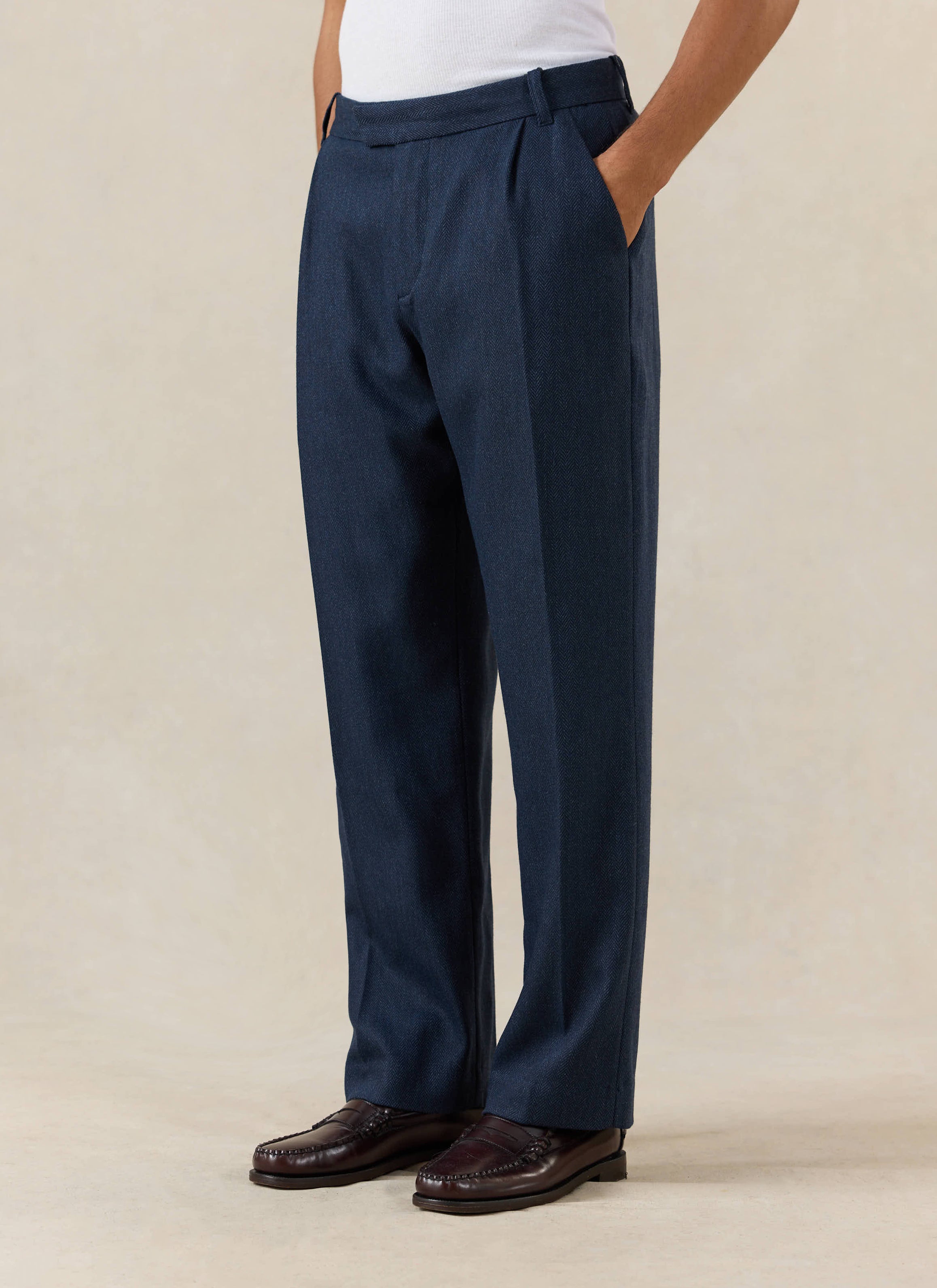 Percival Stanley Pleated Tailored Trousers in navy herringbone wool, styled with brown loafers.