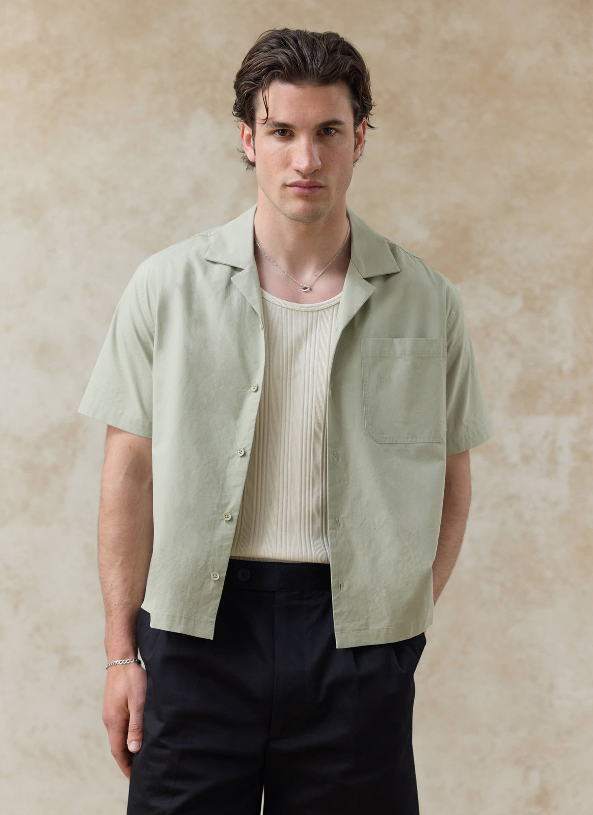 Open Pistachio cotton Percival Daniel Boxy Cuban Shirt with a cream vest; want more? check out our SS26 collection.