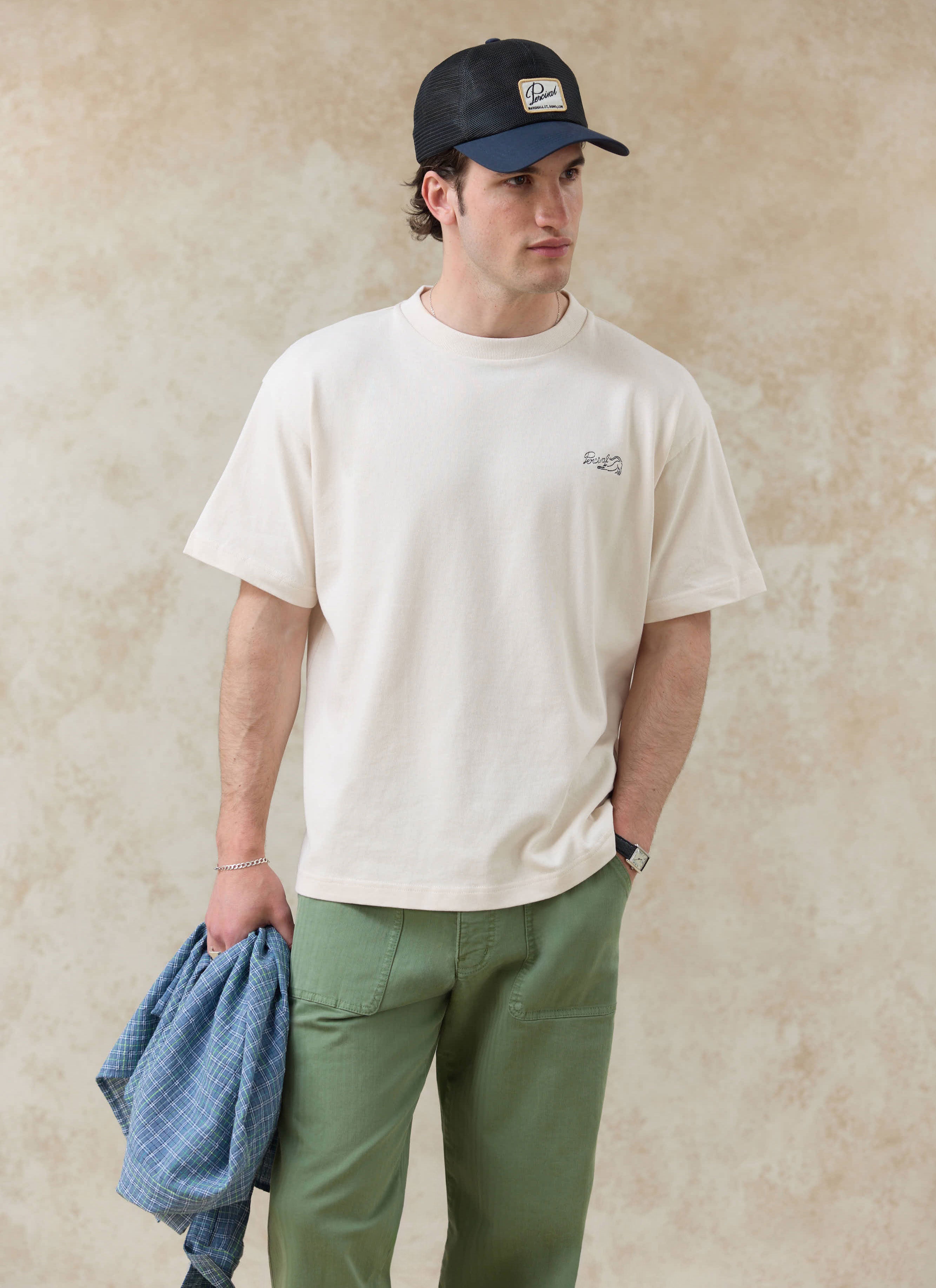 The cream Percival Clarke embroidered organic cotton t-shirt, styled with green trousers from the SS26 collection.