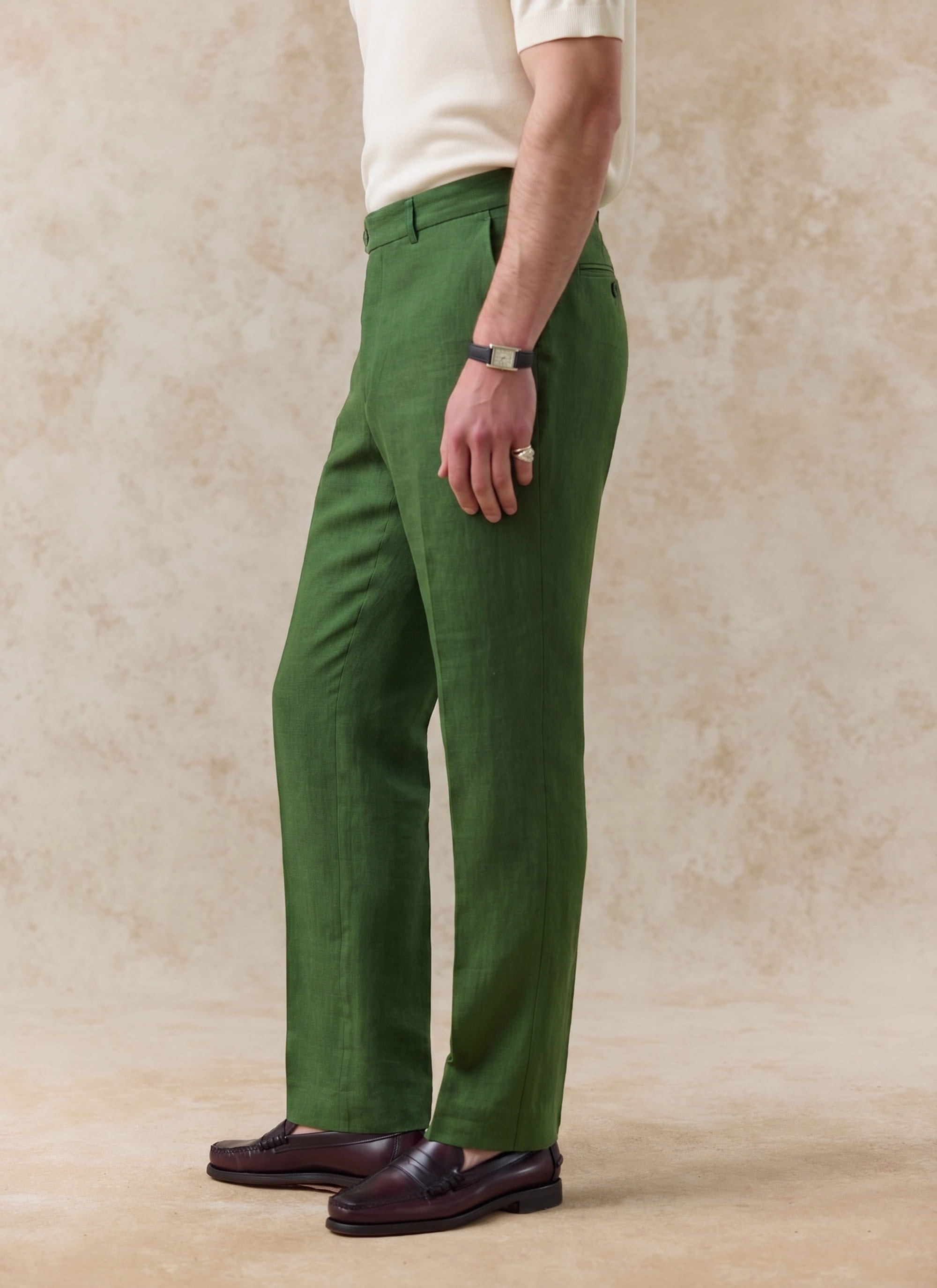Side profile of the forest green Percival Tailored Linen Trousers, featuring a straight leg fit in textured 100% linen.