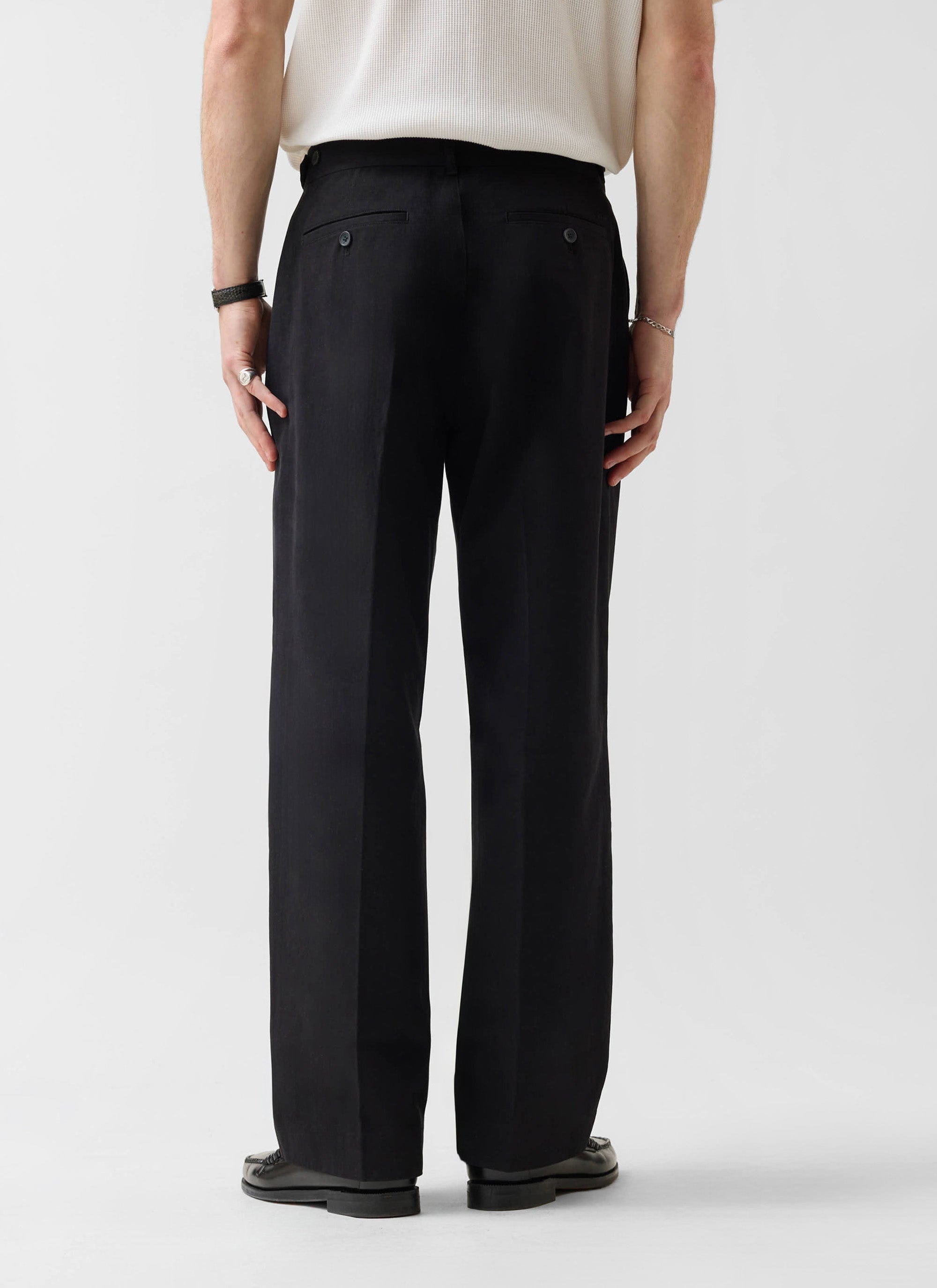 A model shot from behind wearing the black cotton Wide Leg Chino from Percival, showing the relaxed silhouette.