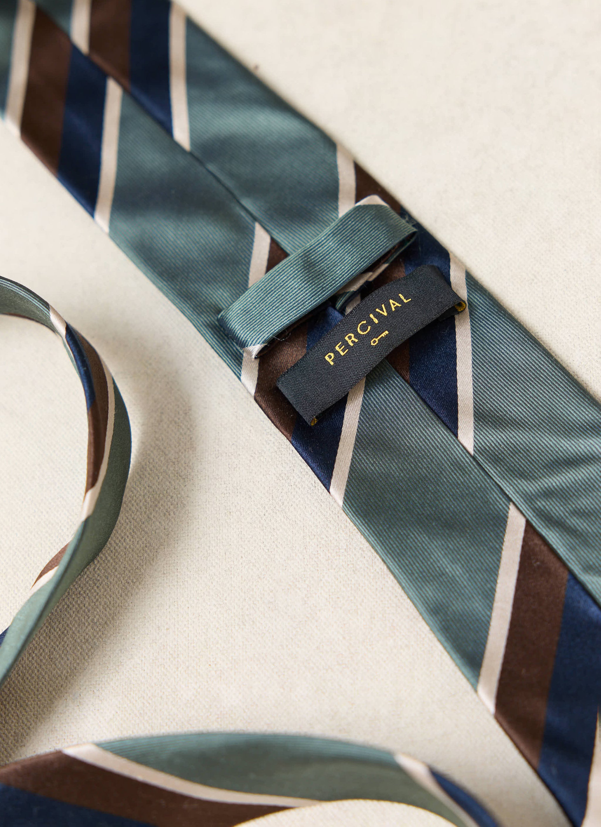 Multi, a close-up showing the forest green, navy and brown stripes and woven label.