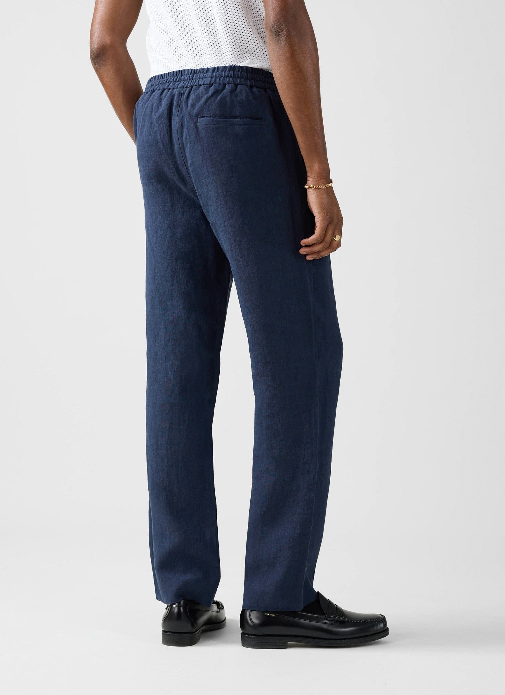 A model wears the navy linen Lorena Wide Leg Trousers from Percival, showing the elasticated waist and relaxed wide-leg fit.