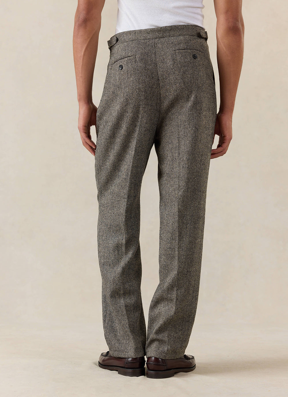 Back view of a model wearing the Percival Blake Double Pleated Tailored Trousers in grey birdseye wool.