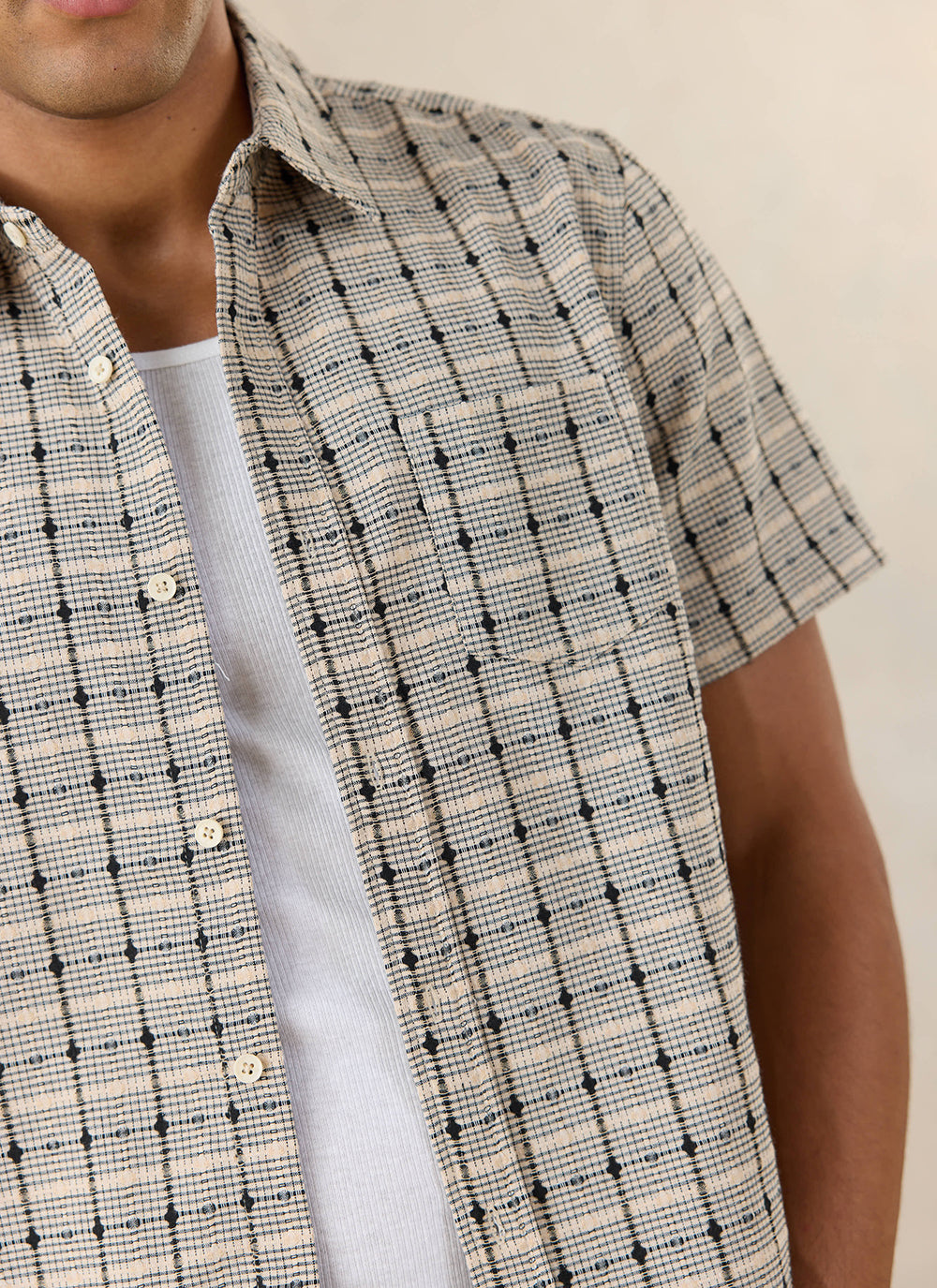 Close-up of the textured Percival Bayley check shirt in cream cotton, showcasing the geometric pattern.