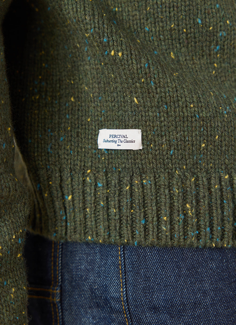 Close-up of the forest green Percival Rhodes boxy knitted crew, highlighting the flecked cotton-blend and brand tag.