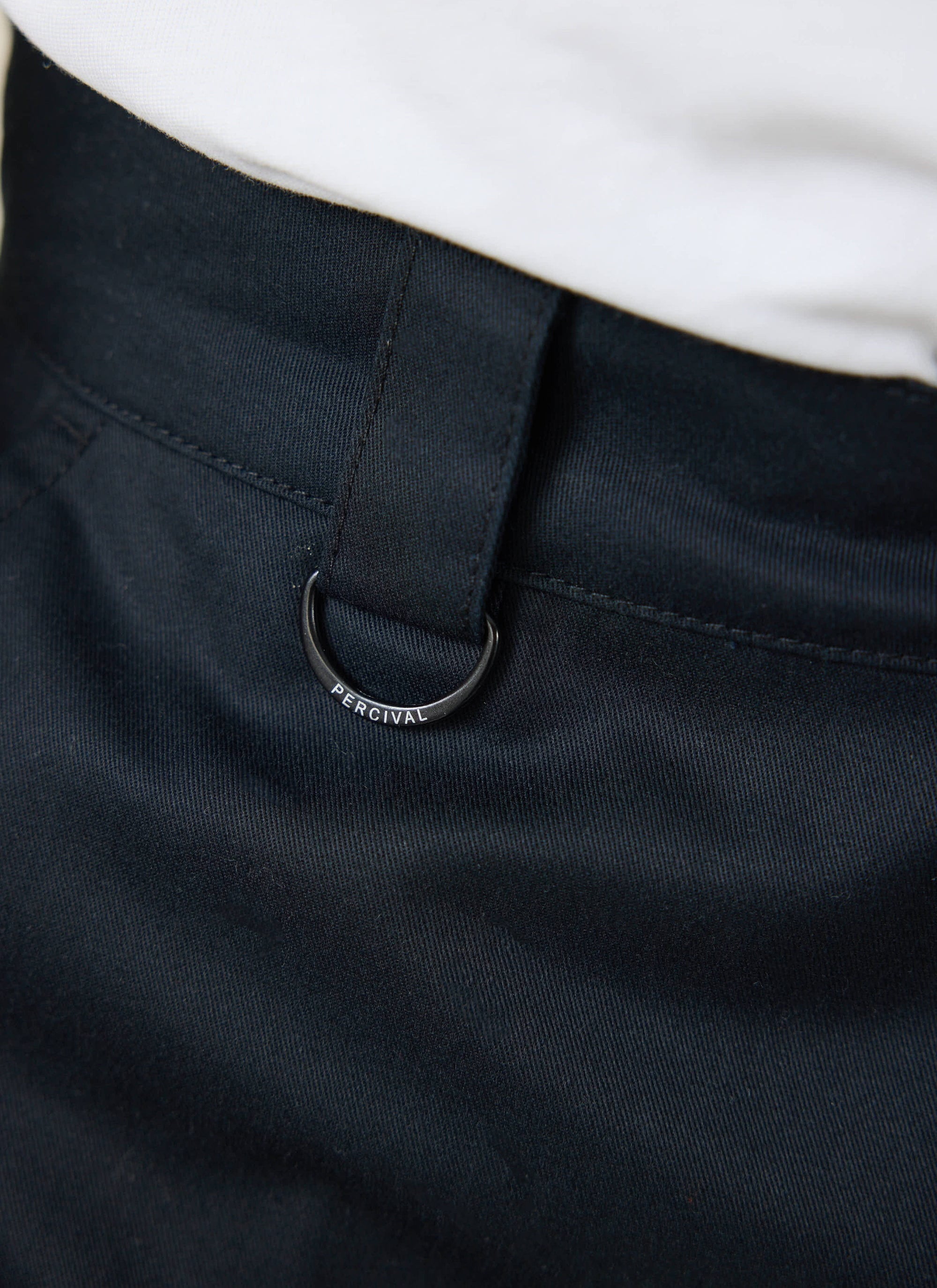 Close-up of the Percival branded D-ring detail on the black twill Straight Leg Trousers.