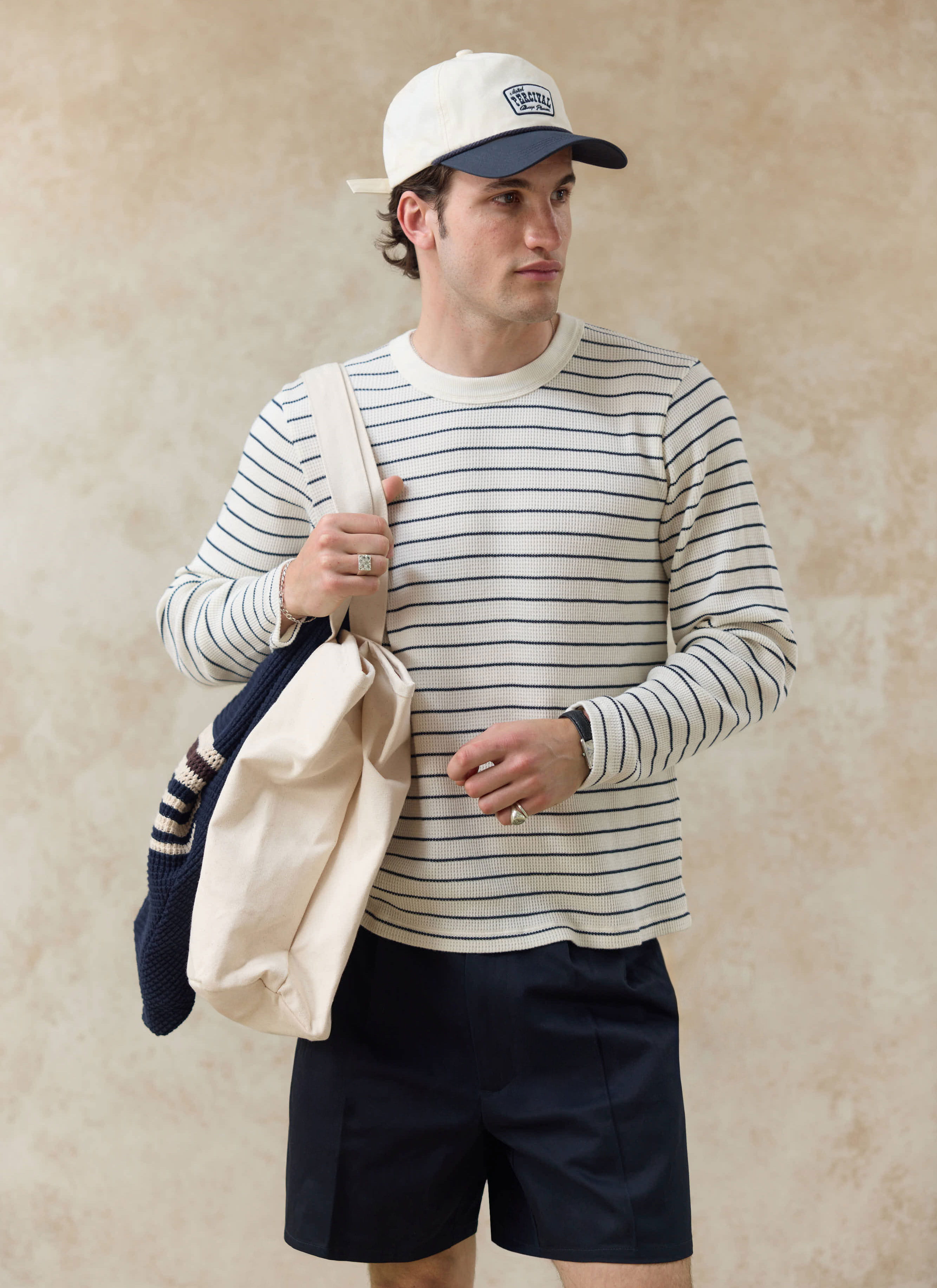 Percival Ernie waffle long sleeve tee in cream stripe worn with the cream Donovan soft trucker cap and navy shorts.