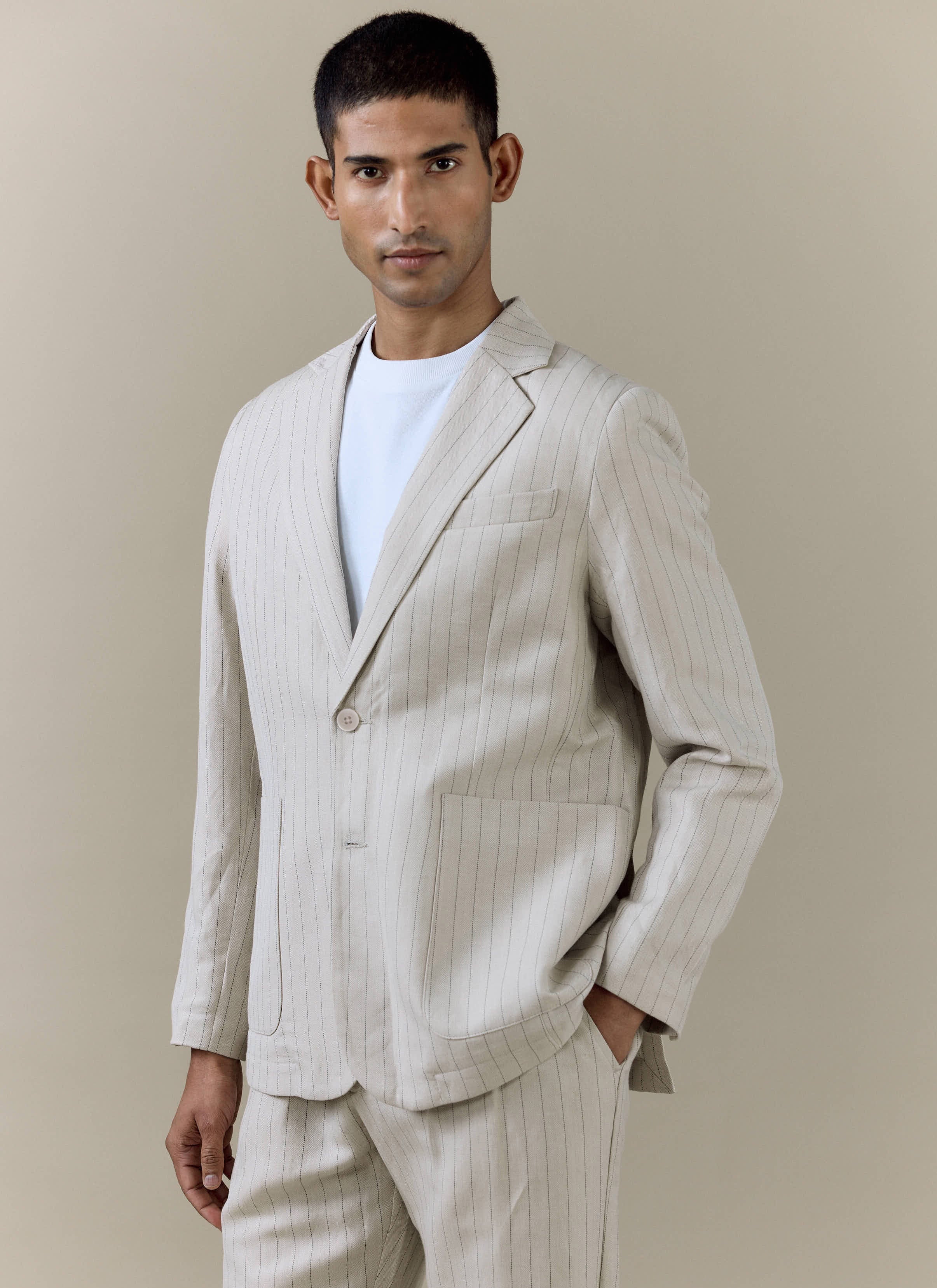 A model wears the cream Striped Tailored Blazer from Percival over a white t-shirt, paired with matching striped trousers.