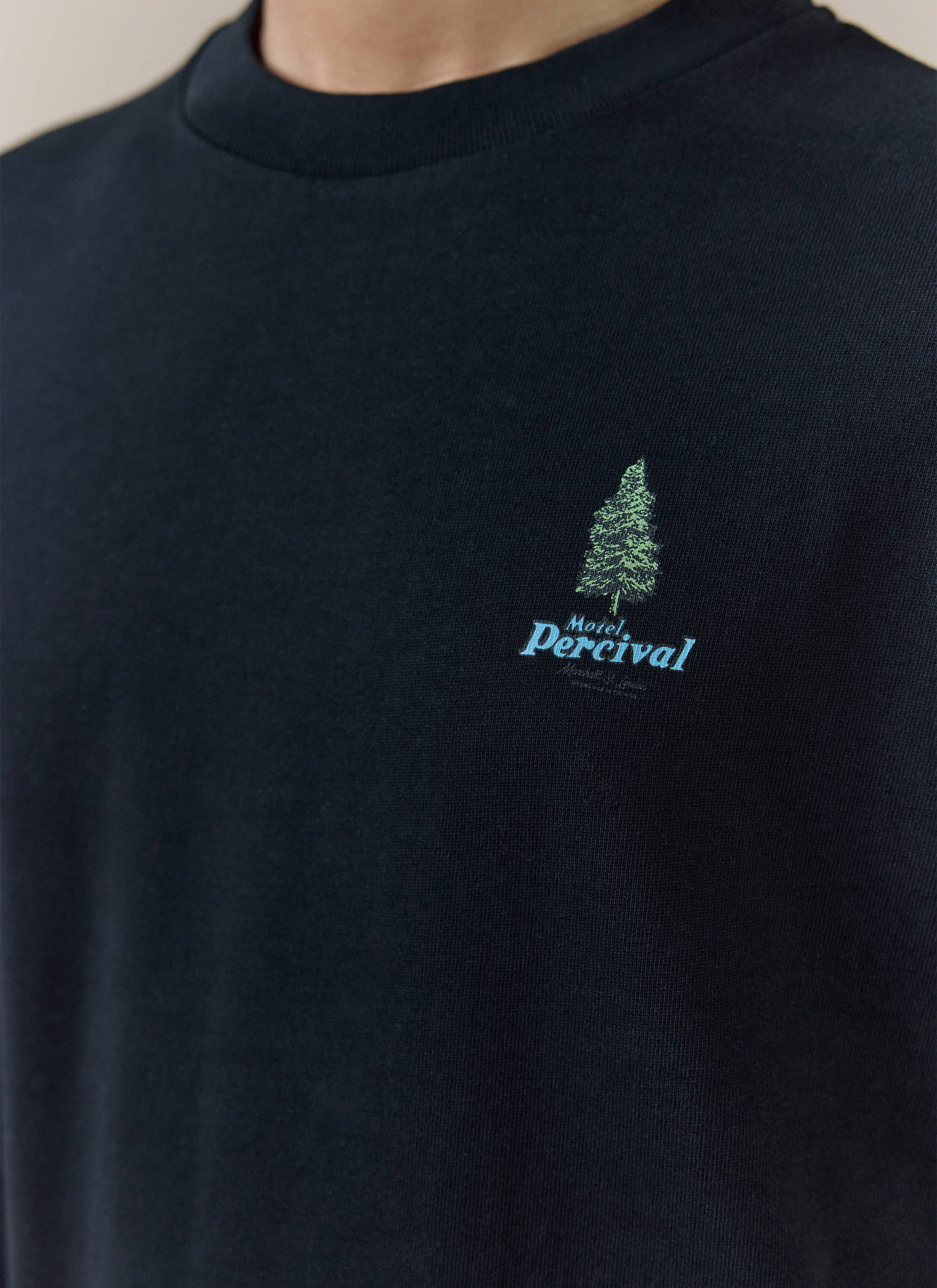 Close-up of the black Percival Arnold Oversized T Shirt, featuring a green tree and blue Motel Percival chest graphic.