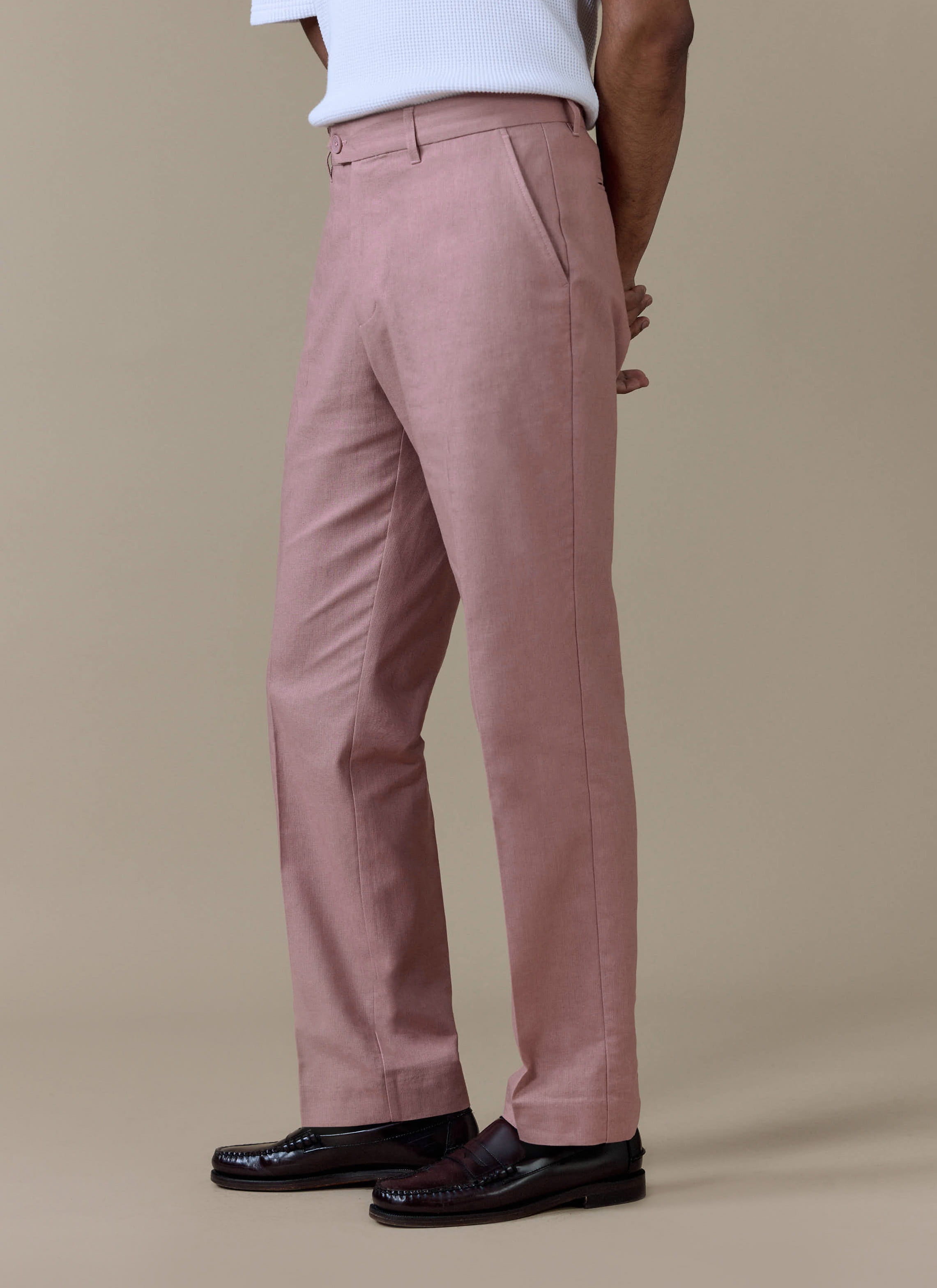 Percival tailored linen trousers in dusty pink with a straight leg and sharp centre crease, styled with loafers.