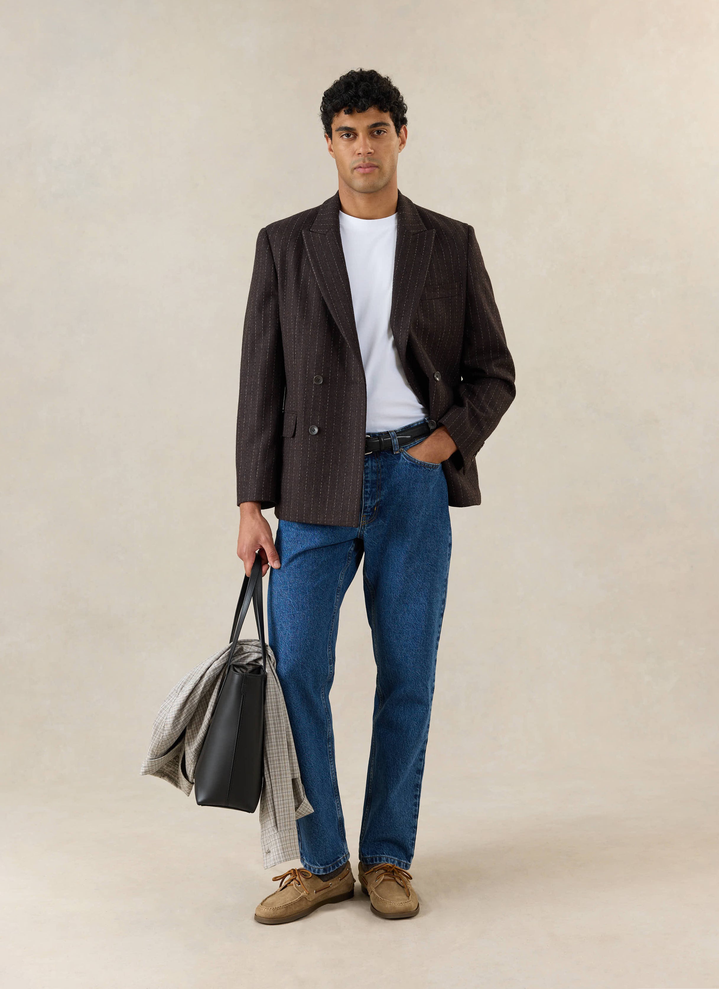 A model wears the Percival Clifton Pinstripe Double Breasted Blazer in espresso wool with blue jeans and a white t-shirt.