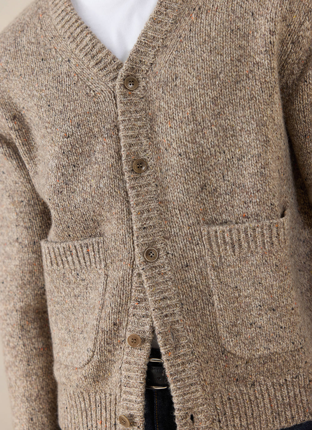 Close-up of the oak Percival Rhodes Cardigan, showing the textured cotton blend knit, button details and patch pockets.