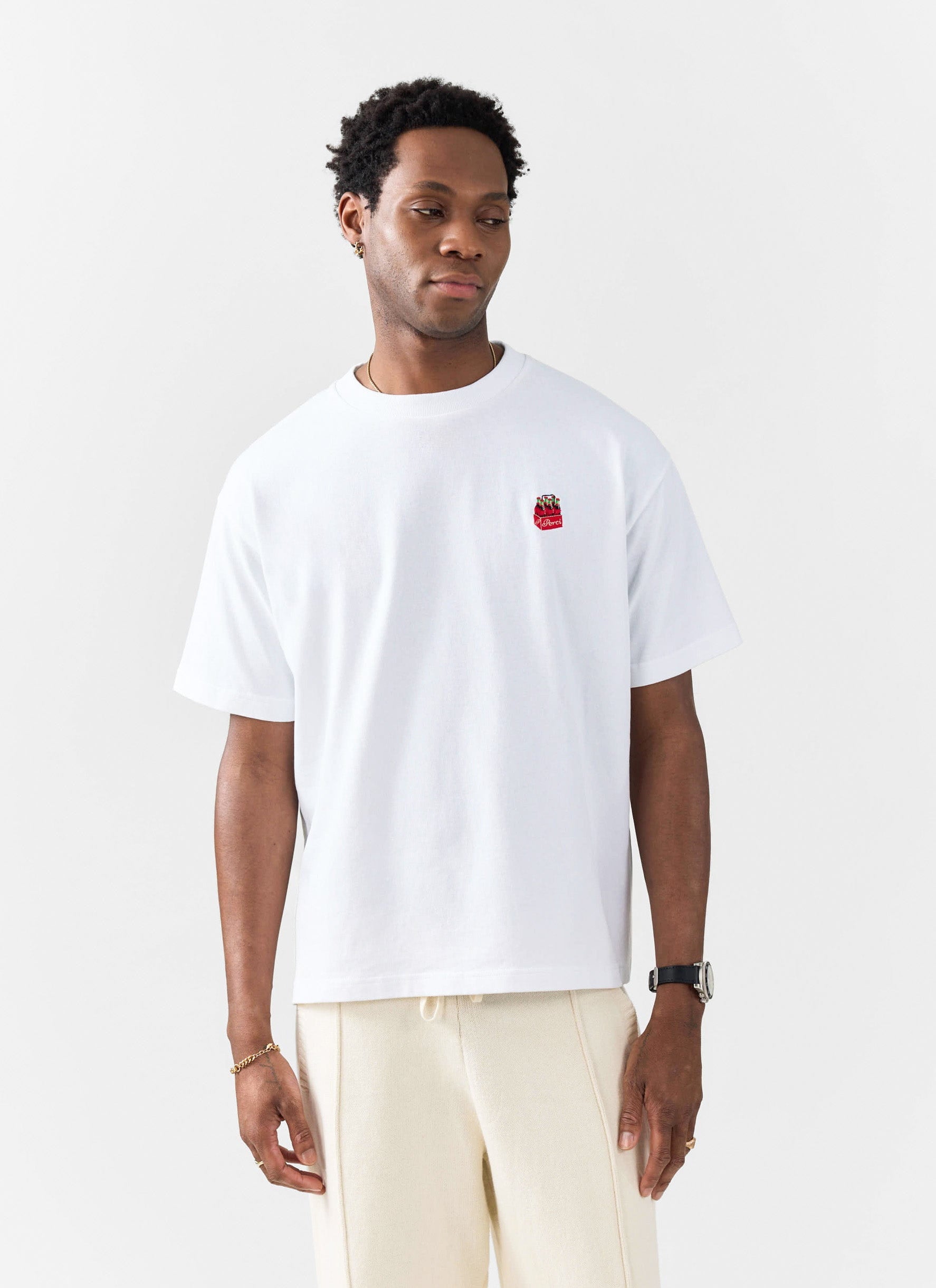 A model wears the Percival Soda Bottles oversized embroidered t-shirt in white against a plain studio background.