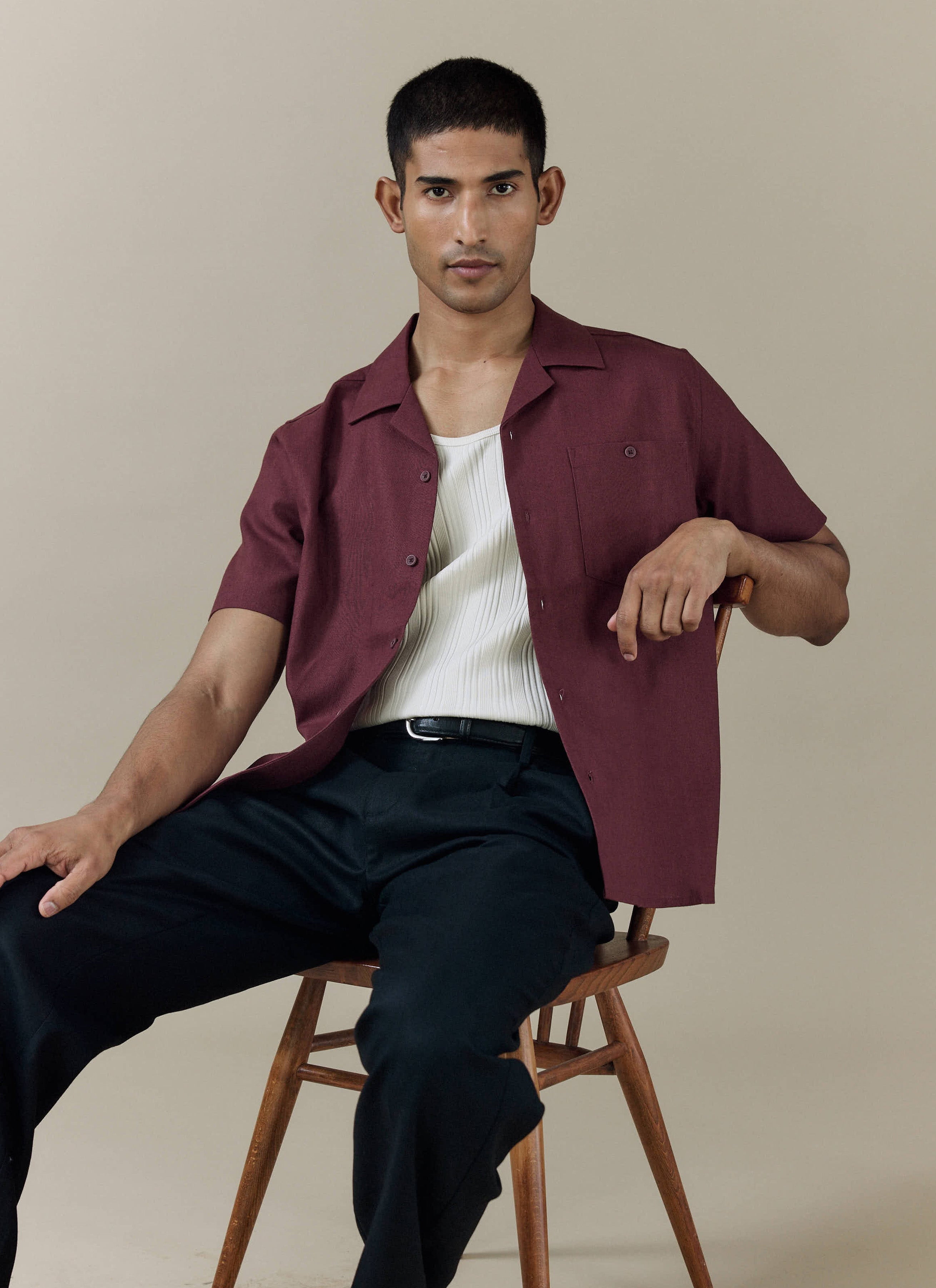 Percival Short Sleeve Cuban Shirt in Merlot linen-cotton blend, styled open over a white ribbed vest and trousers.