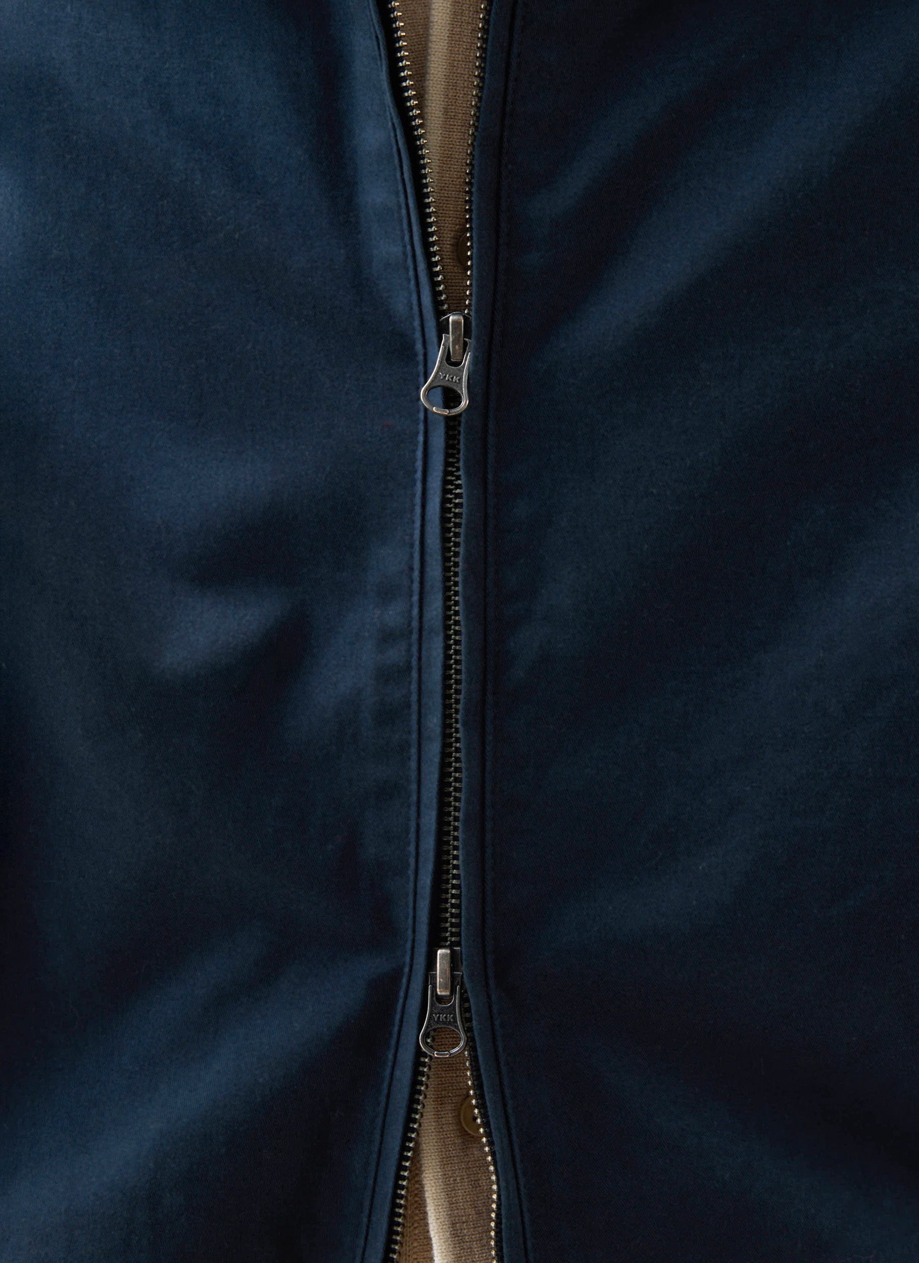 A close-up of the two-way zip detail on the navy cotton Leo Harrington jacket from Percival.
