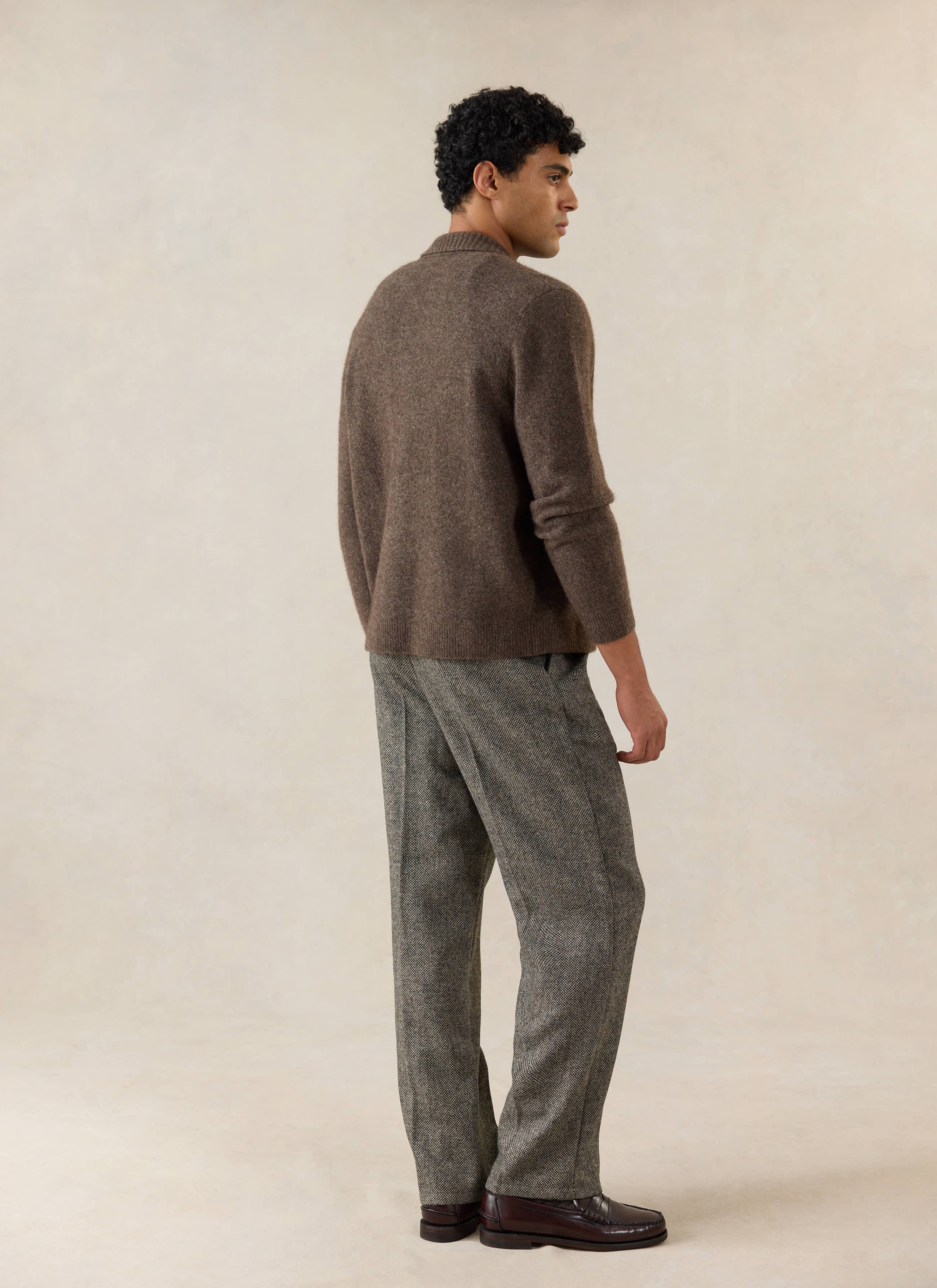 A model wears the brown Percival Archive Knit Collared Cardigan in yak wool, styled with grey trousers in a studio shot.