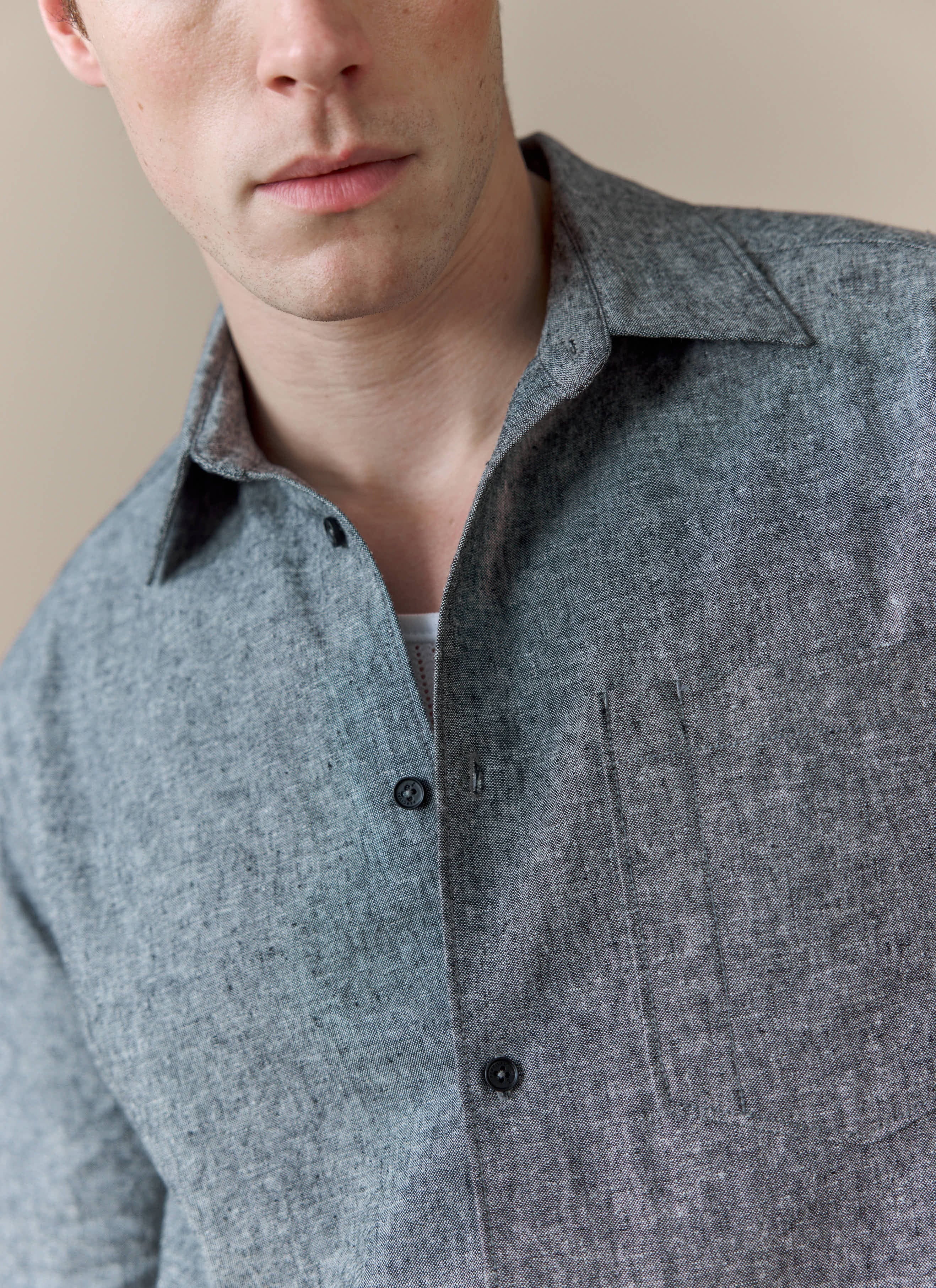 A close-up of a model wearing the Percival Textured Boxy Shirt in grey, showing the detail of the cotton-linen fabric.