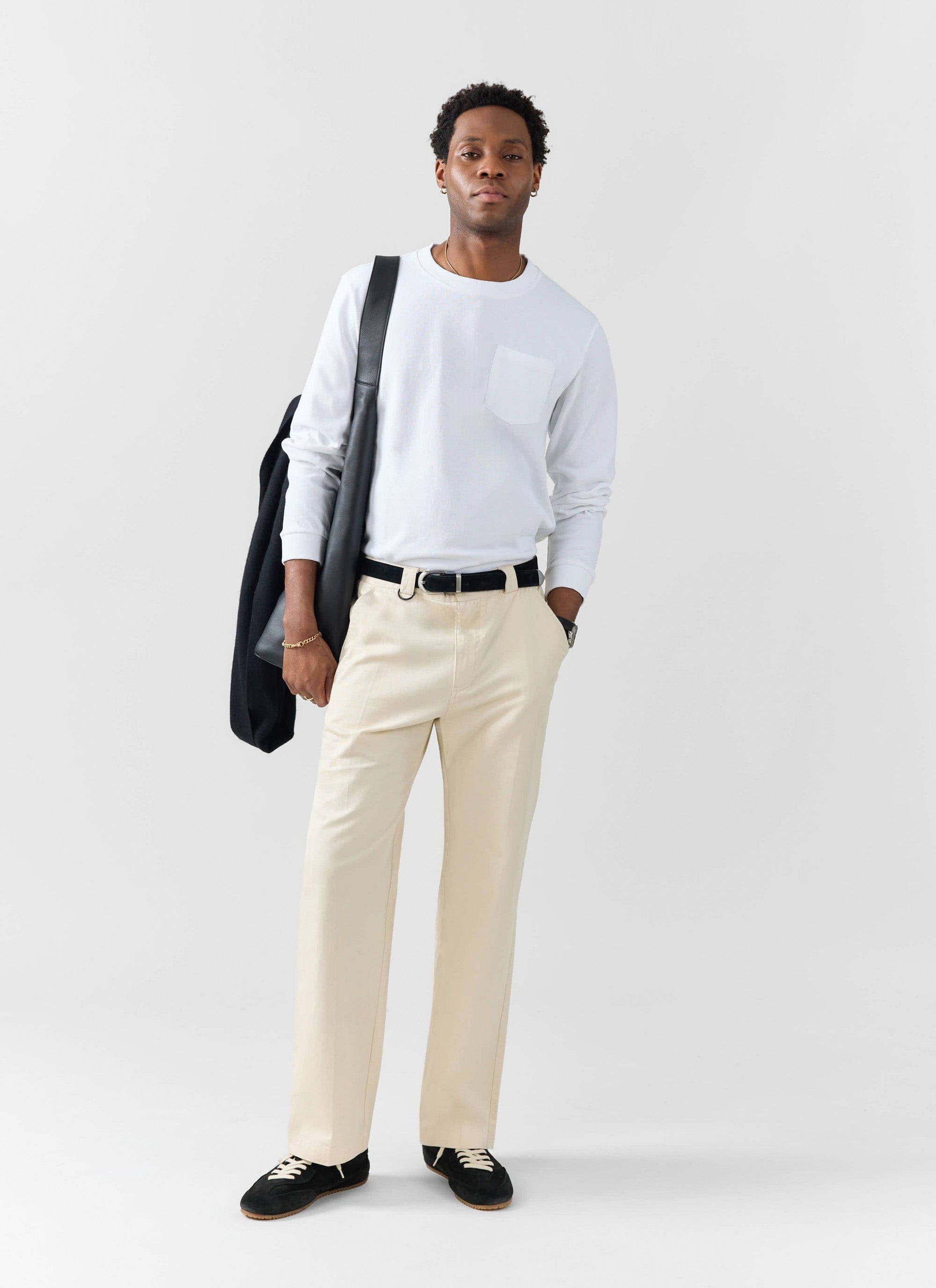 A model wears the white Long Sleeve Pocket T Shirt from Percival, paired with cream trousers against a white background.