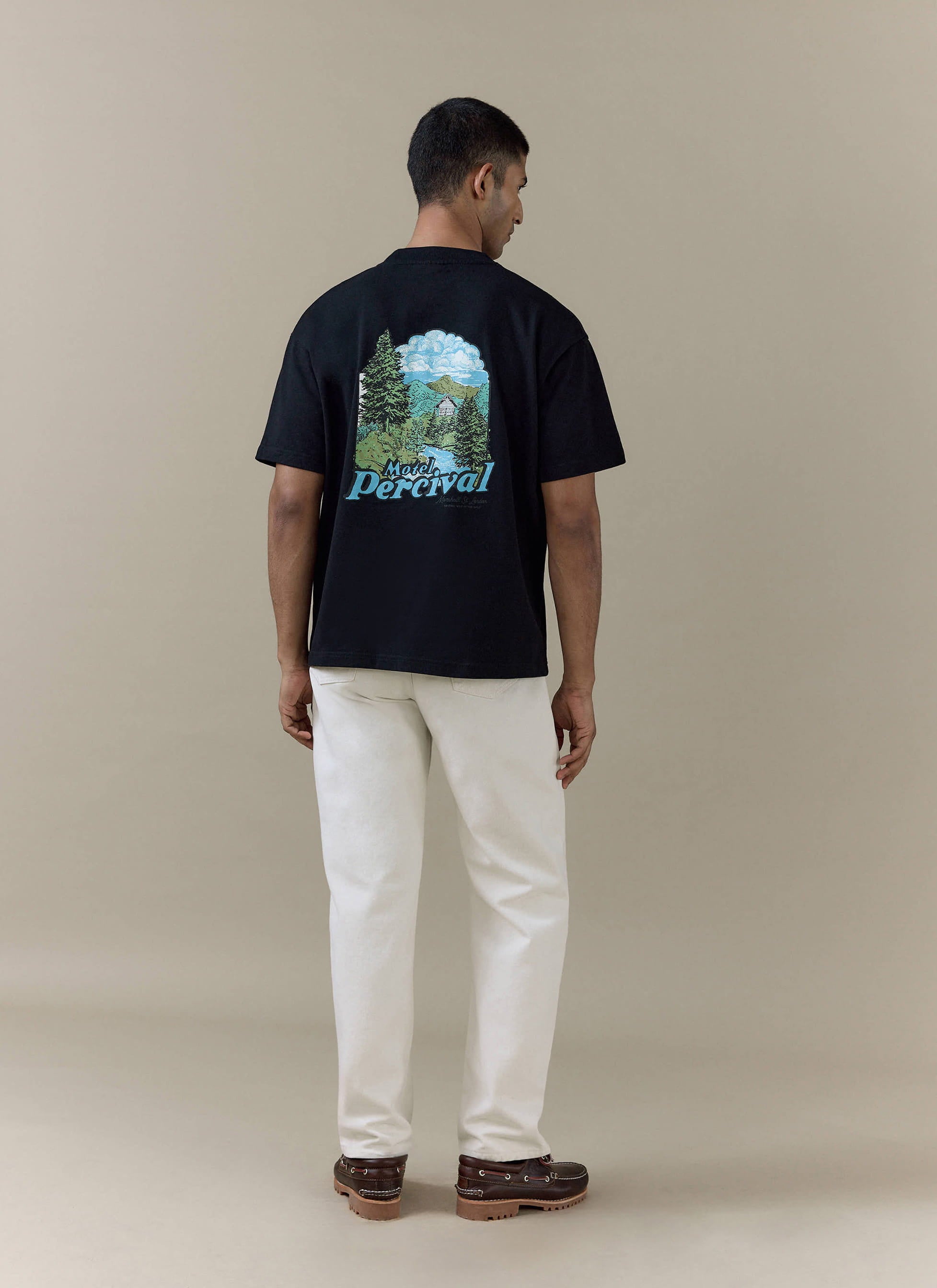 Rear view of the black organic cotton Percival Arnold Oversized T Shirt with colourful Motel Percival scenic graphic.