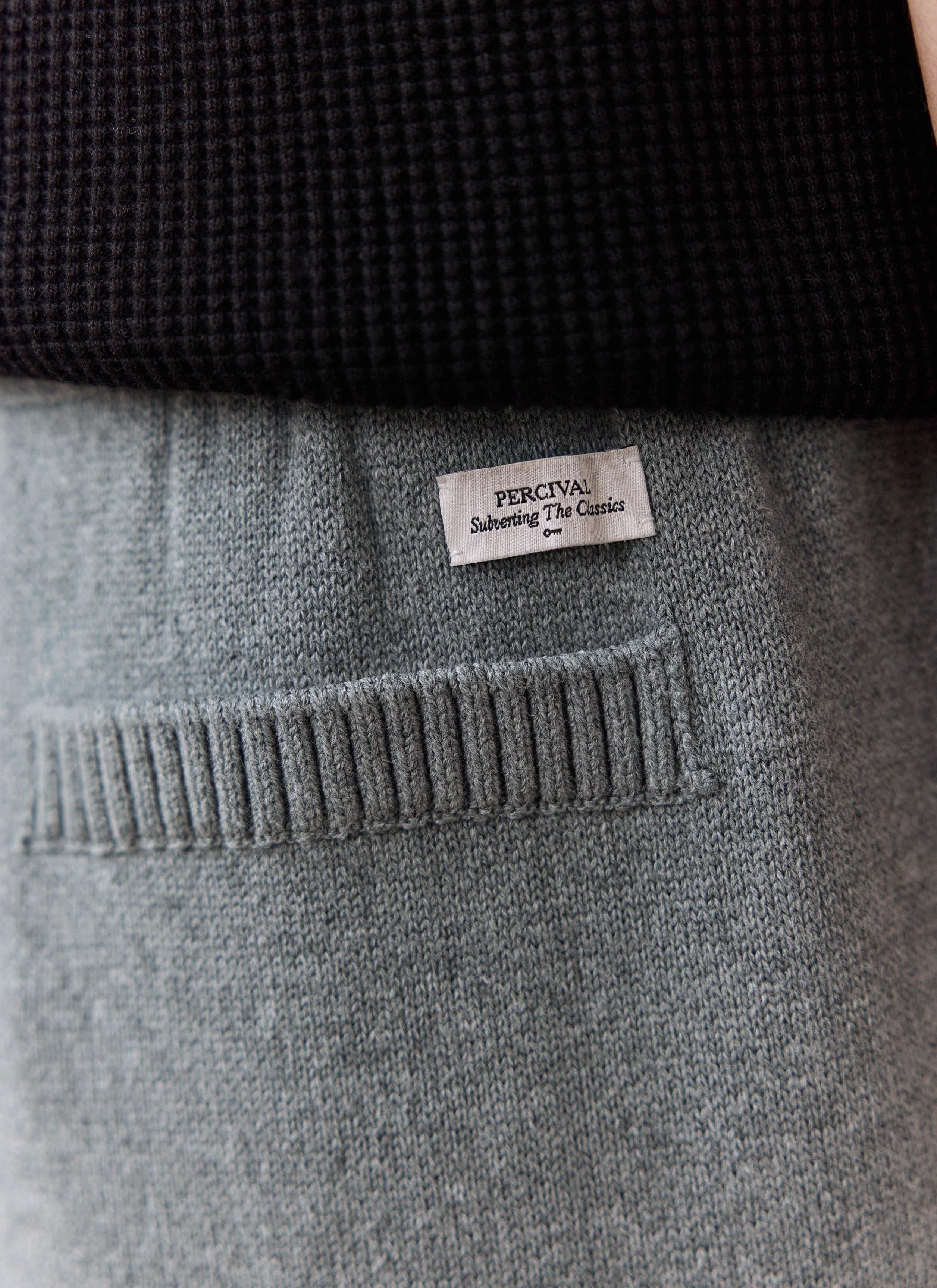 A close-up of the back pocket on the grey Chronicle Knitted Trackpant, showing the woven Percival label.