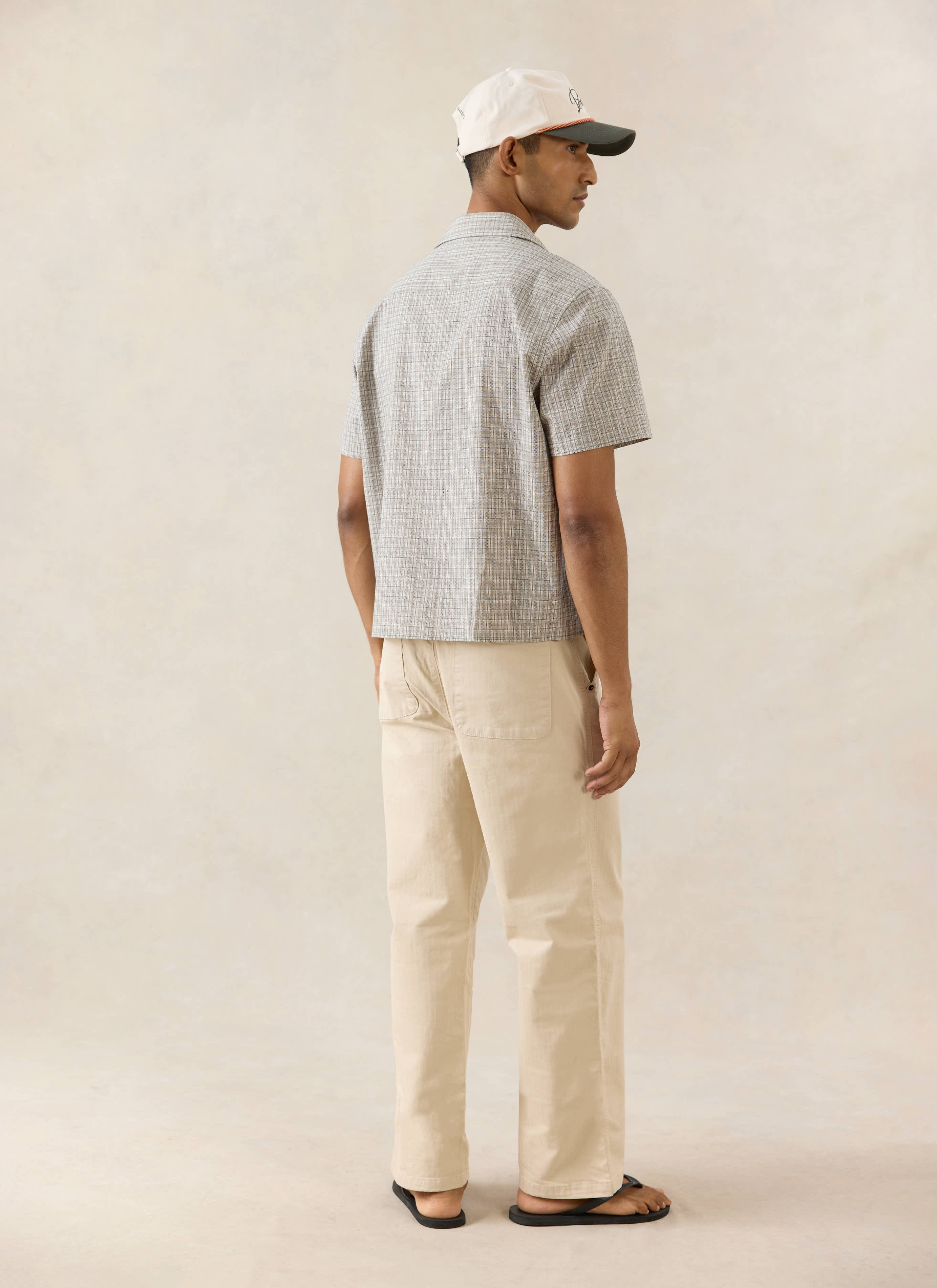 Percival Hinsley cream check boxy short sleeve shirt, styled with a Spencer cap and Lucas carpenter trousers from the back.