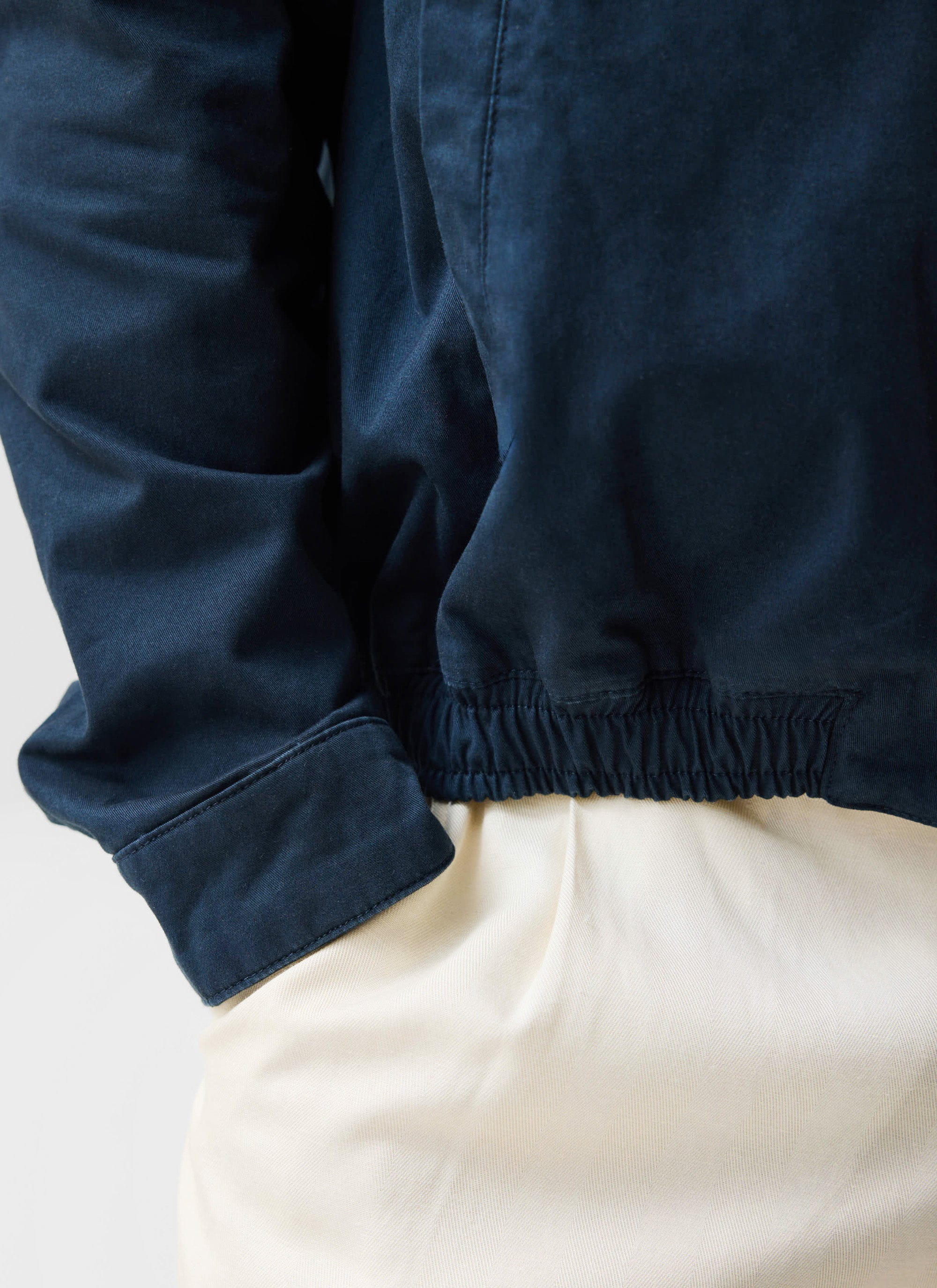 A close-up of the navy cotton Percival Leo Harrington Jacket, showing the elasticated hem and cuff detail.