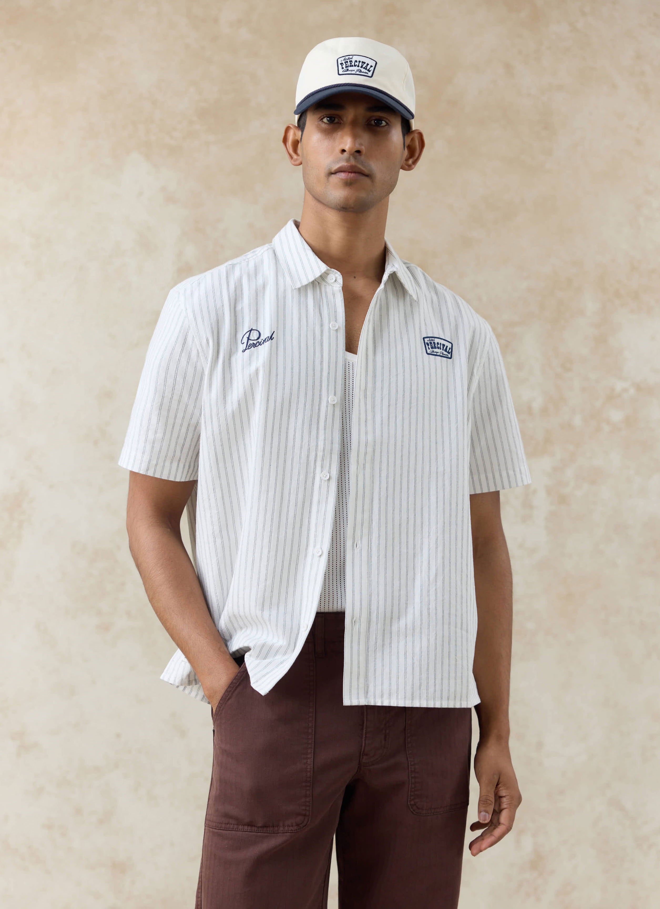 Model wearing the Percival Lucia Embroidered Shirt in cream stripe and the cream Donovan Soft Trucker Cap.