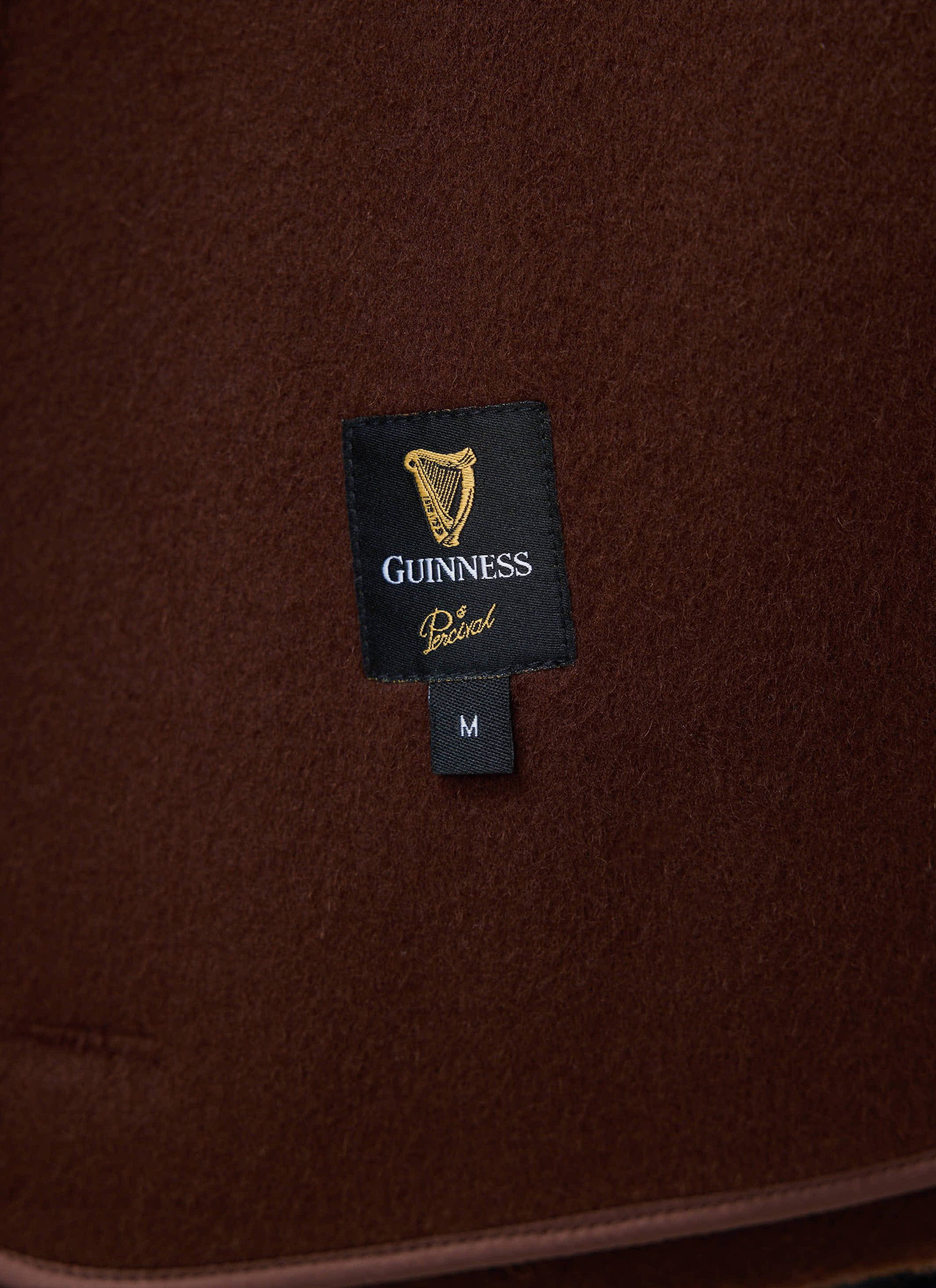 Close-up of the Guinness x Percival collaboration label woven into the espresso wool jacket by Percival.