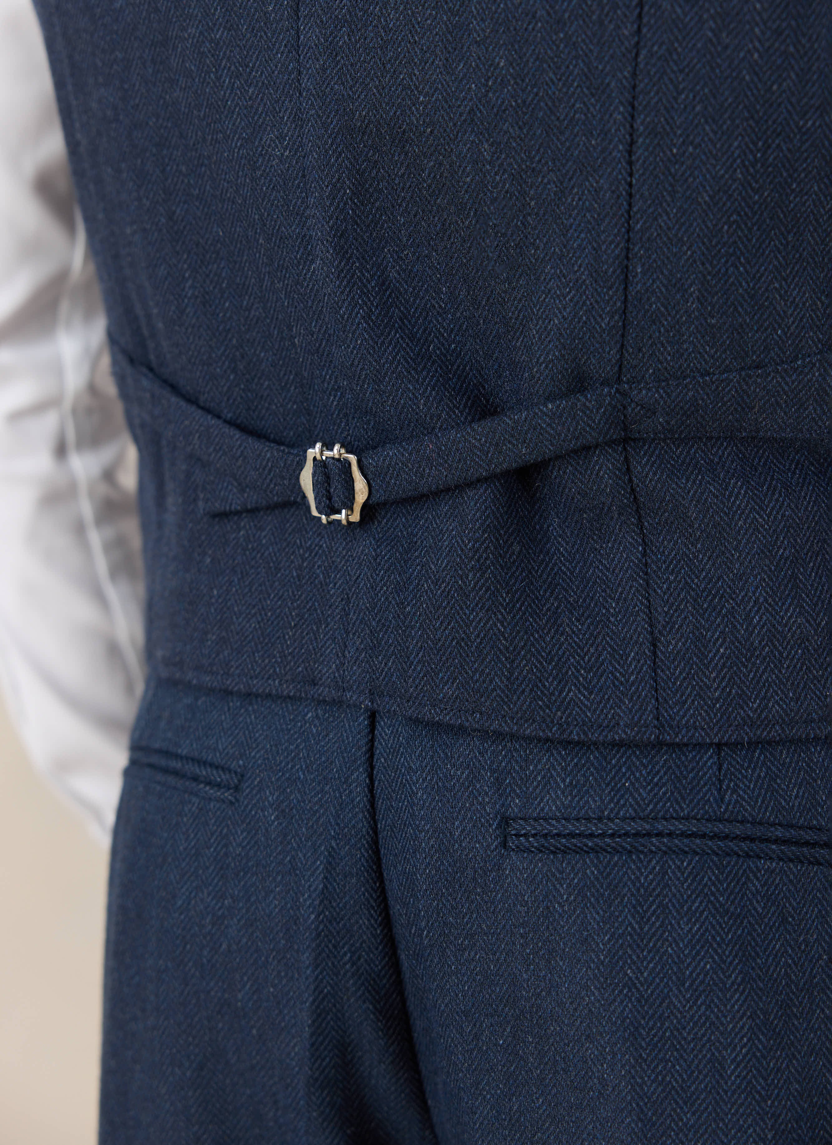 Detailed back view of the Percival Stanley Tailored Waistcoat in navy herringbone wool, showing the adjustable cinch.